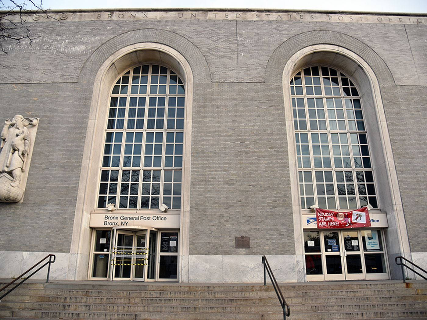 Post Office 桌布 壁紙 — 布朗克斯總郵局的大型灰色磚砌外牆，帶有拱形窗戶和通往玻璃門的石階。