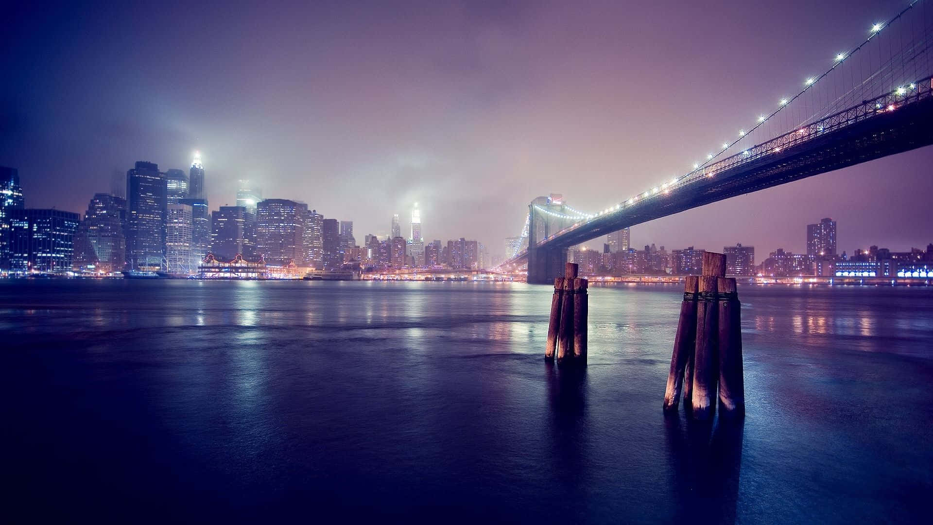 Photography Desktop 桌布 壁紙 — 布魯克林大橋和曼哈頓天際線的壯麗夜景，平靜的水面倒映著閃爍的城市燈光。