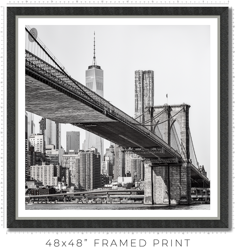 Picture Frame 桌布 壁紙 — 布魯克林大橋在水面上拱起，背景有摩天大樓和世界貿易中心一號大樓的黑白景觀。