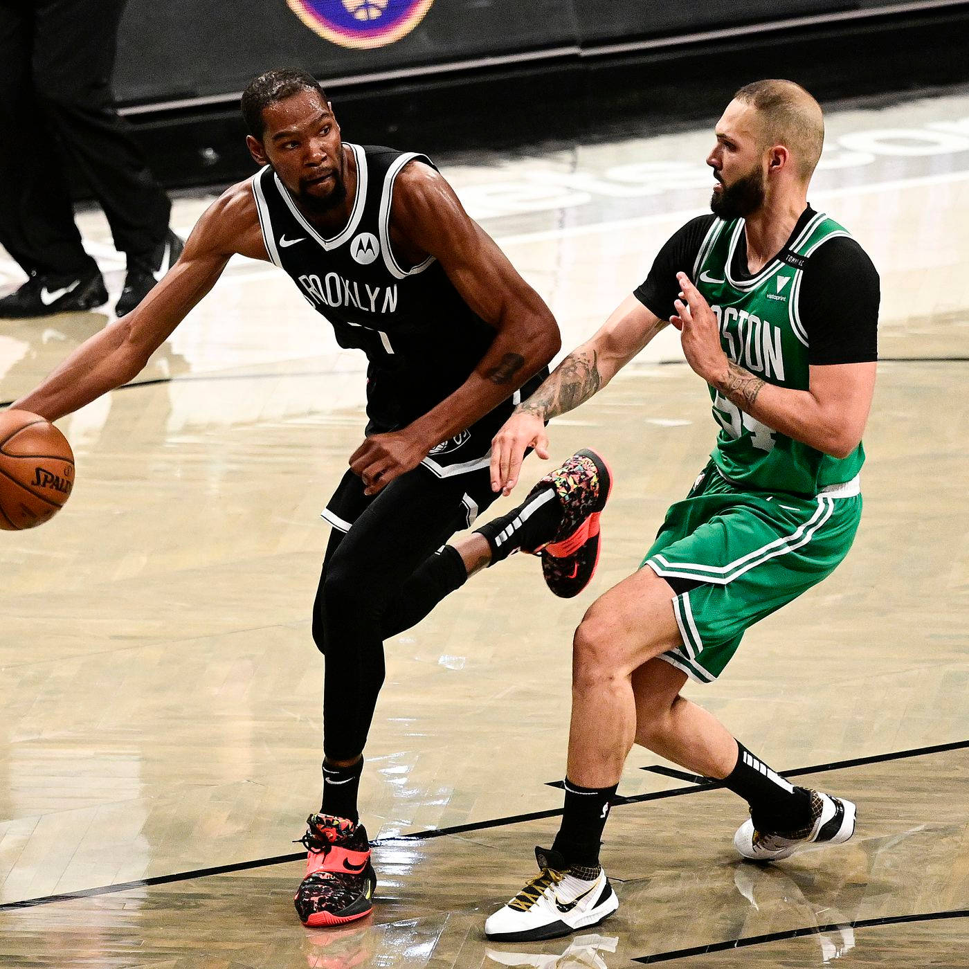 Brooklyn Nets 桌布 壁紙 — 布魯克林籃網球員在拋光籃球場上運球，同時被波士頓塞爾提克球員緊密防守。