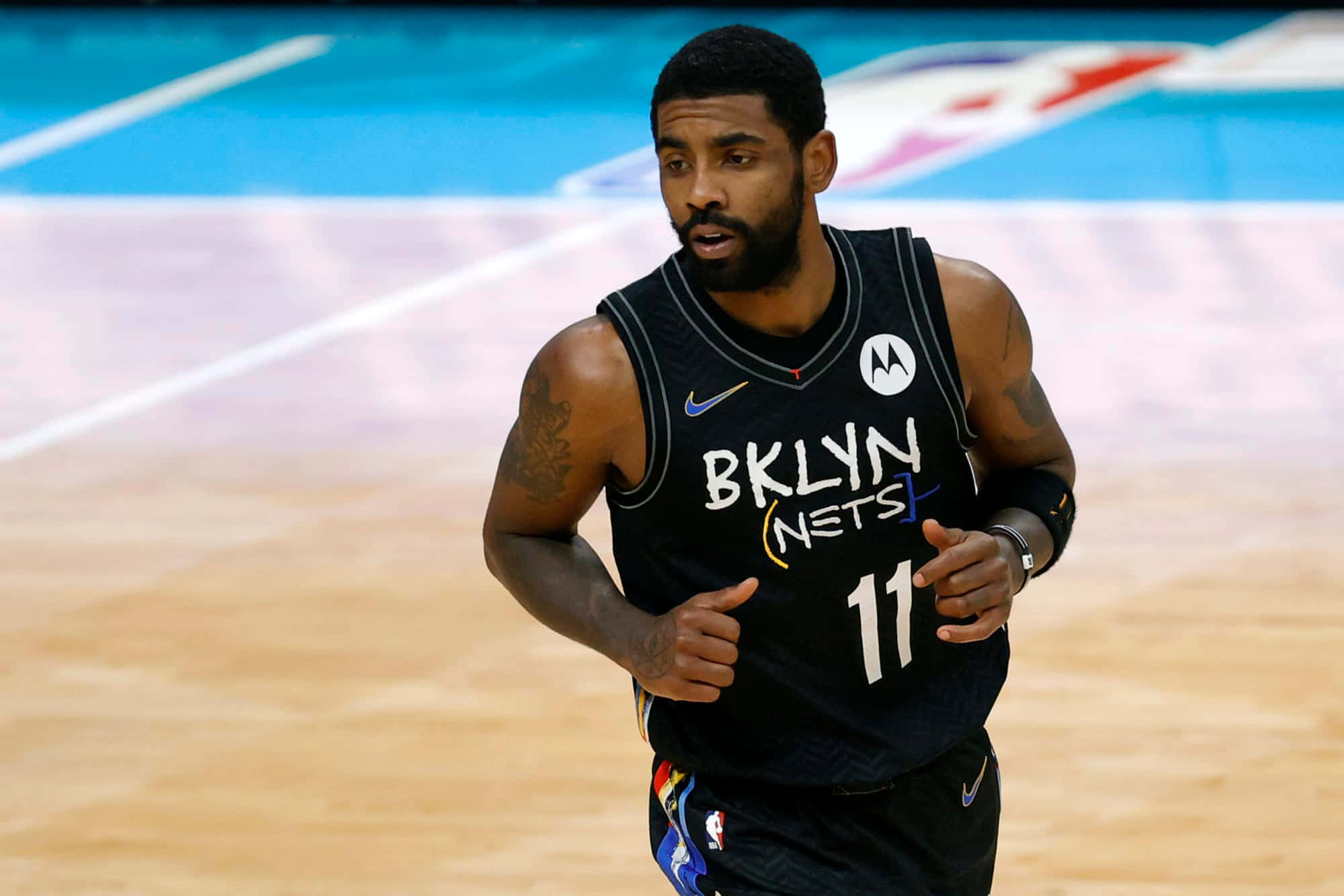 Kyrie Irving Nets 桌布 壁紙 — 布魯克林籃網籃球運動員凱里·厄文身穿黑色球衣在比賽期間於硬木球場上奔跑。