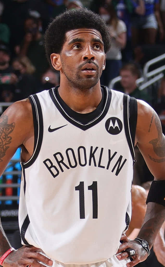 Kyrie Irving Nets 桌布 壁紙 — 布魯克林籃網籃球運動員凱里·歐文身穿白色11號球衣，在比賽中專注，背景有觀眾。