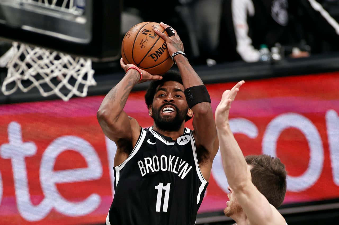 Kyrie Irving Nets 桌布 壁紙 — 布魯克林籃網隊11號球員跳起投籃，防守球員伸手封阻。