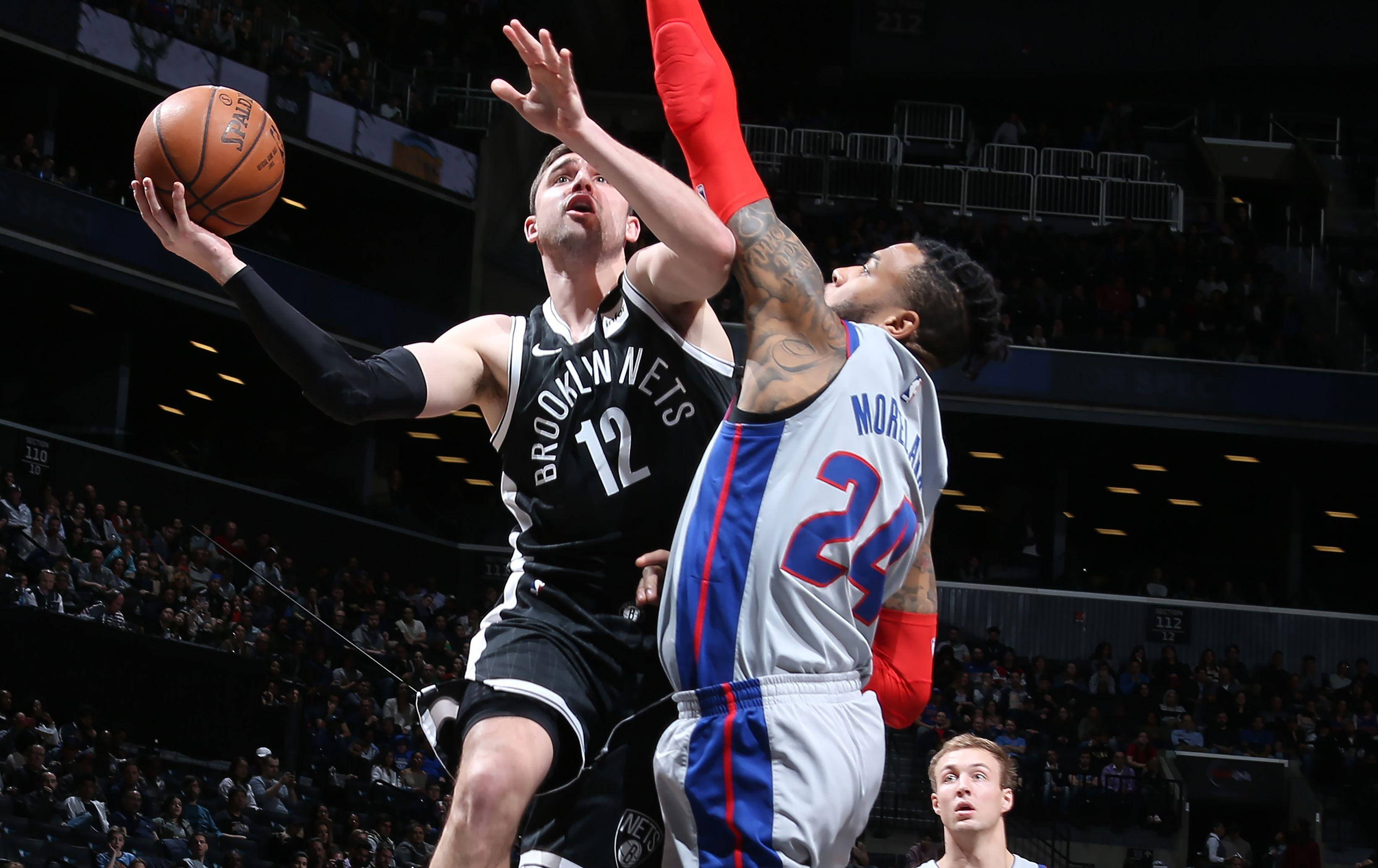 joe harris 桌布 壁紙 — 布魯克林籃網隊12號球員跳起投籃，底特律活塞隊24號防守球員在擠滿觀眾的場館中干擾投籃。