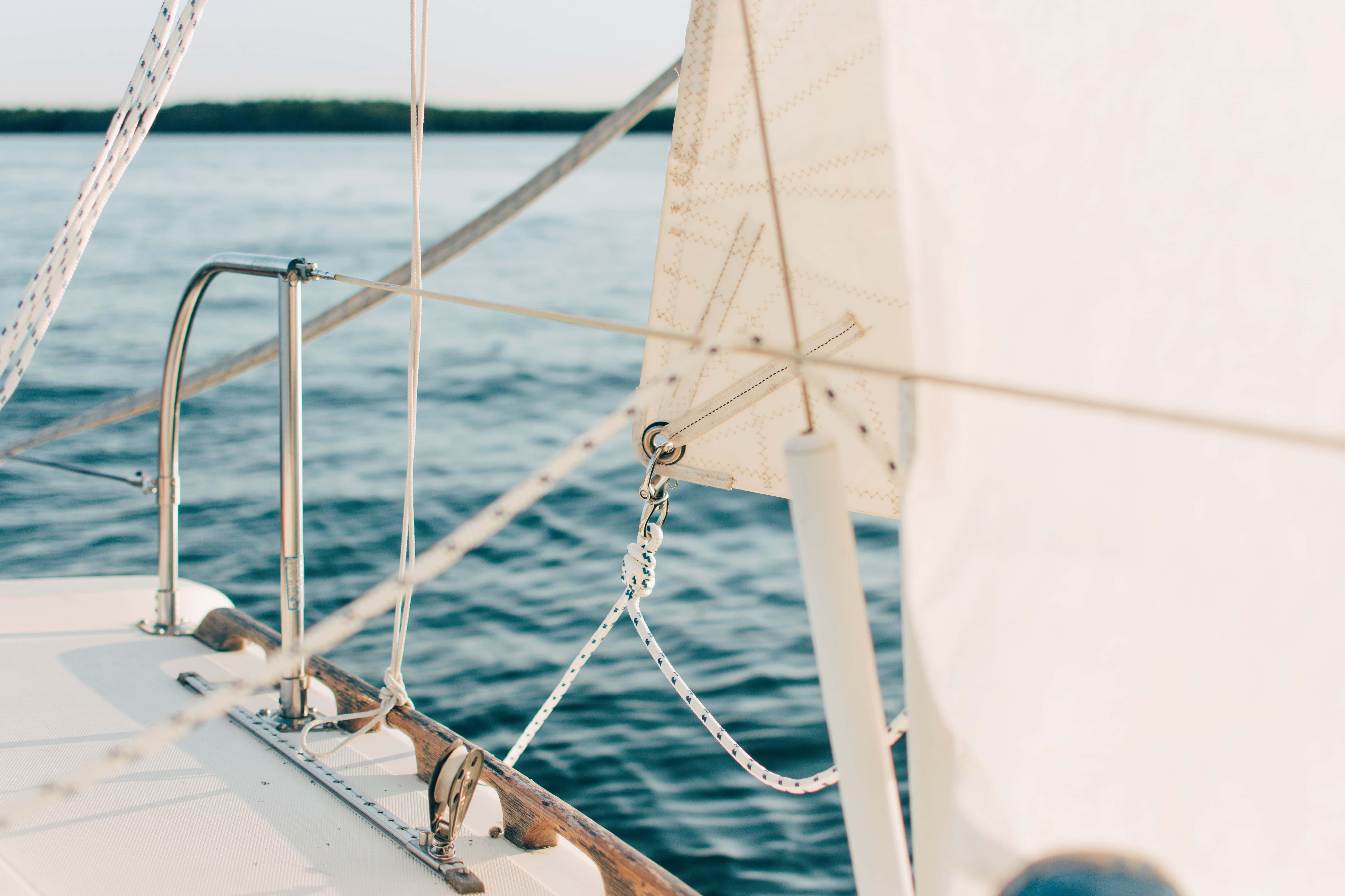 Boating 桌布 壁紙 — 帆船甲板與白色帆布在平靜藍色海水和柔和日光下的特寫。