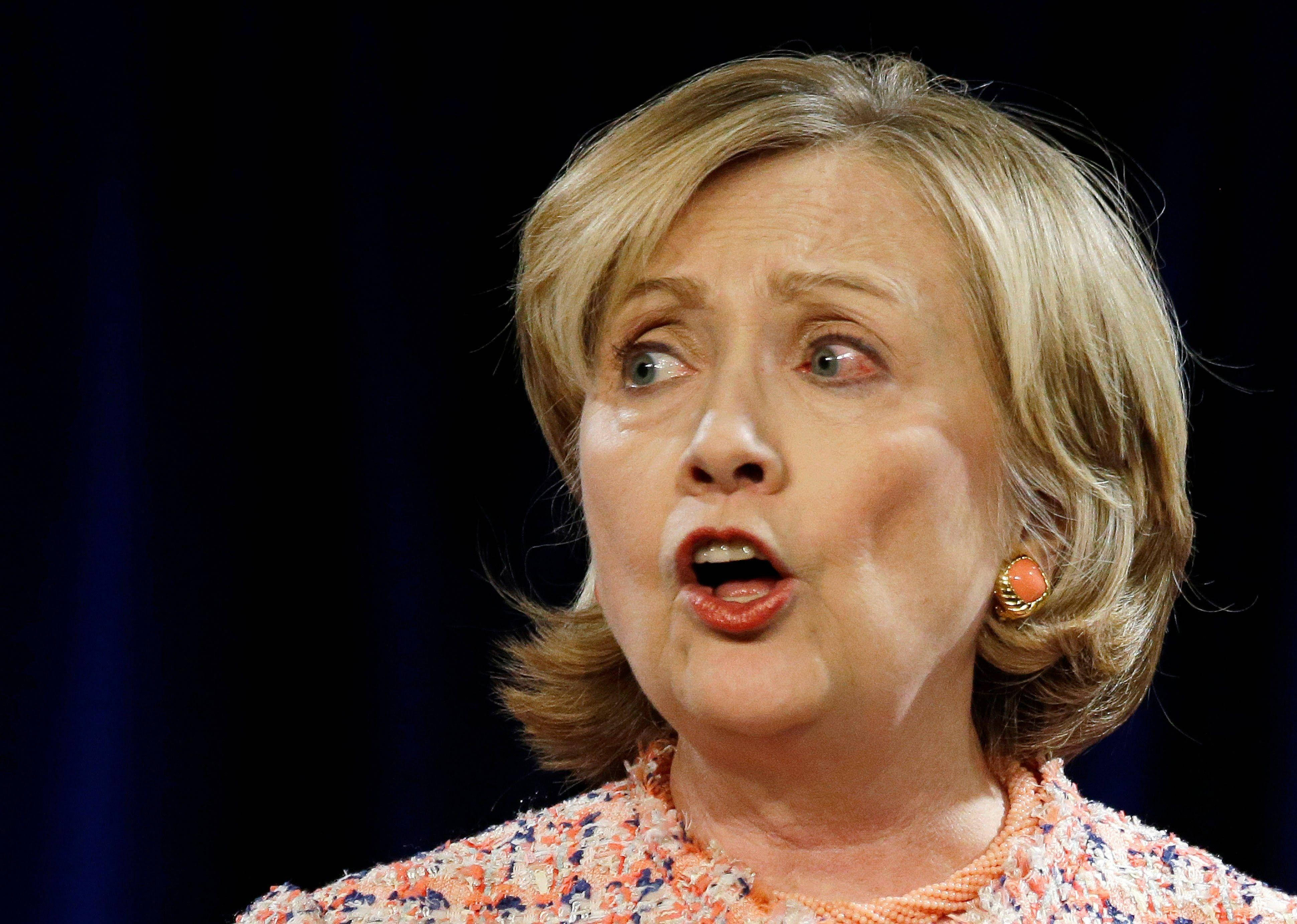 hillary clinton 桌布 壁紙 — 希拉蕊·柯林頓在深藍色窗簾背景下，睜大眼睛、張開嘴巴說話。