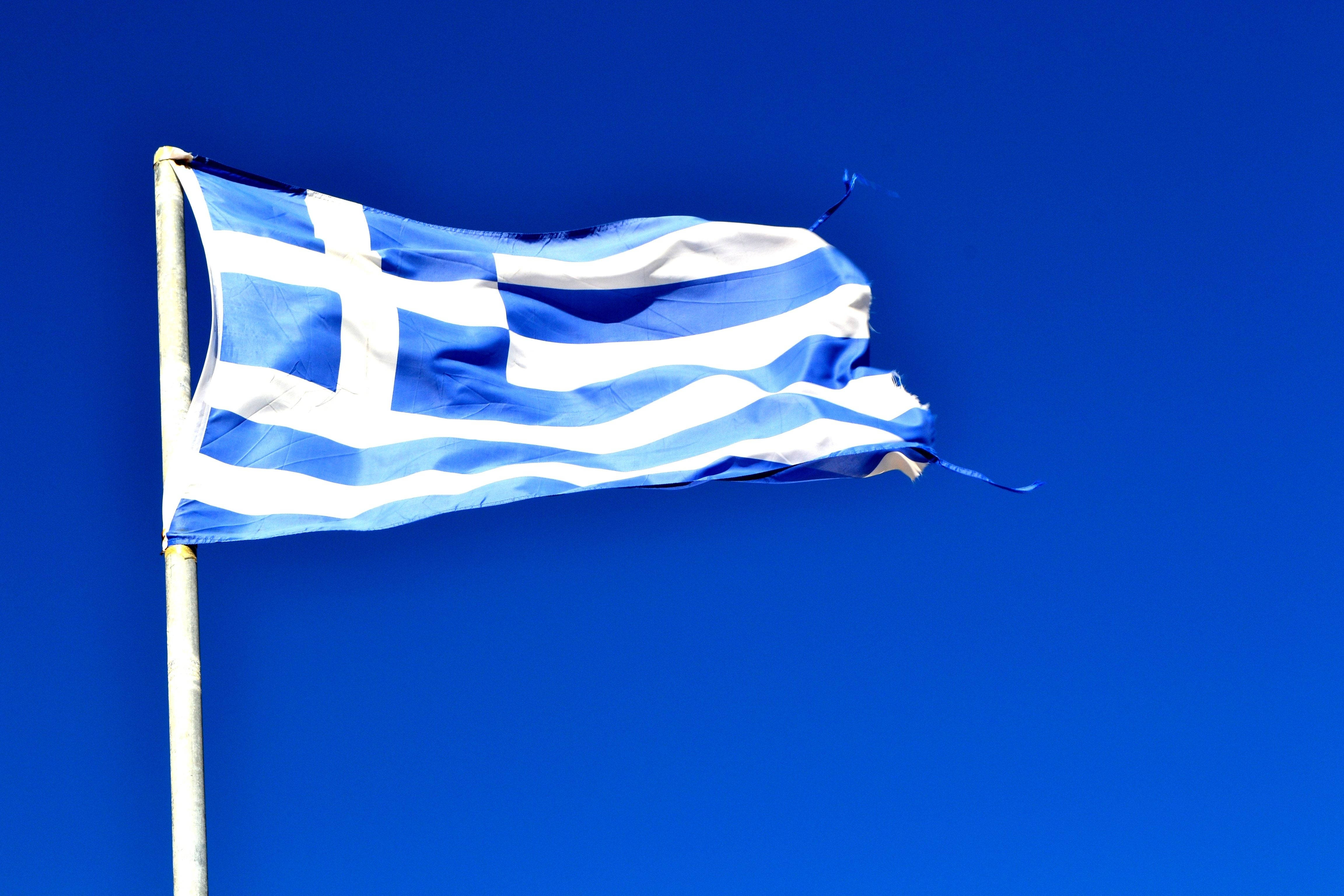 greek 桌布 壁紙 — 希臘國旗，藍白條紋和十字，在鮮明清澈的藍天下動態飄揚。