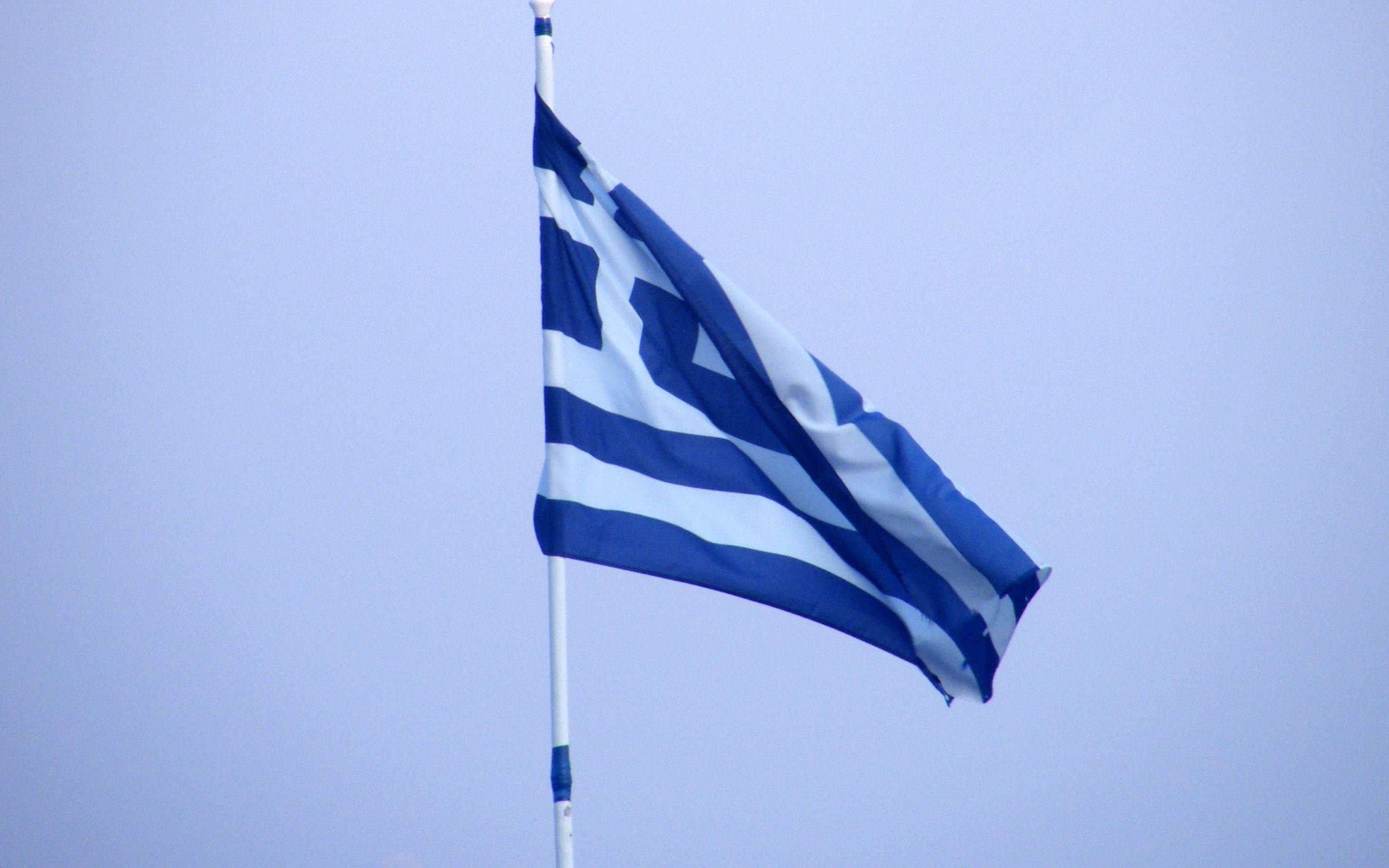 greek 桌布 壁紙 — 希臘國旗，藍白條紋和十字架，在淡藍色天空中飄揚。