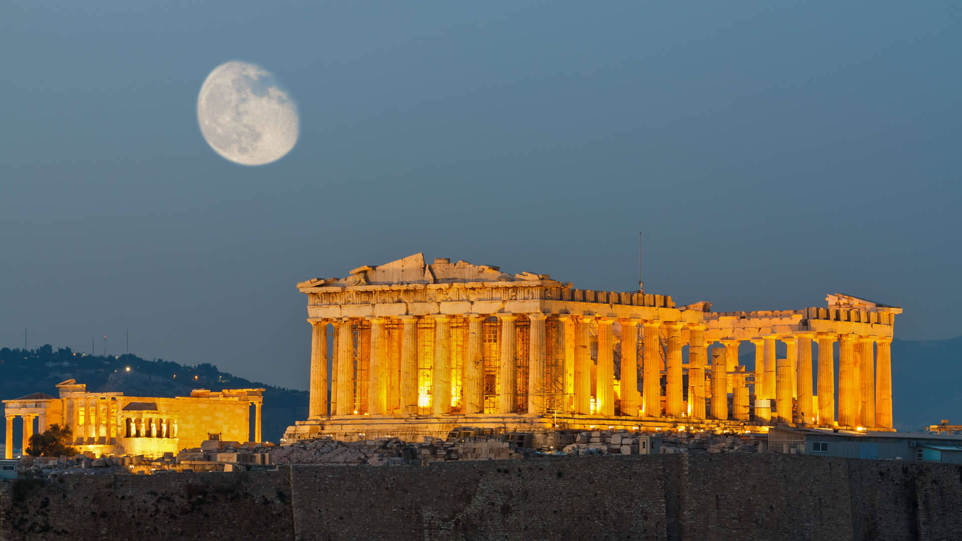 Athens 桌布 壁紙 — 帕德嫩神廟在金色燈光下溫暖地發光，滿月在雅典上空的暮色中升起。