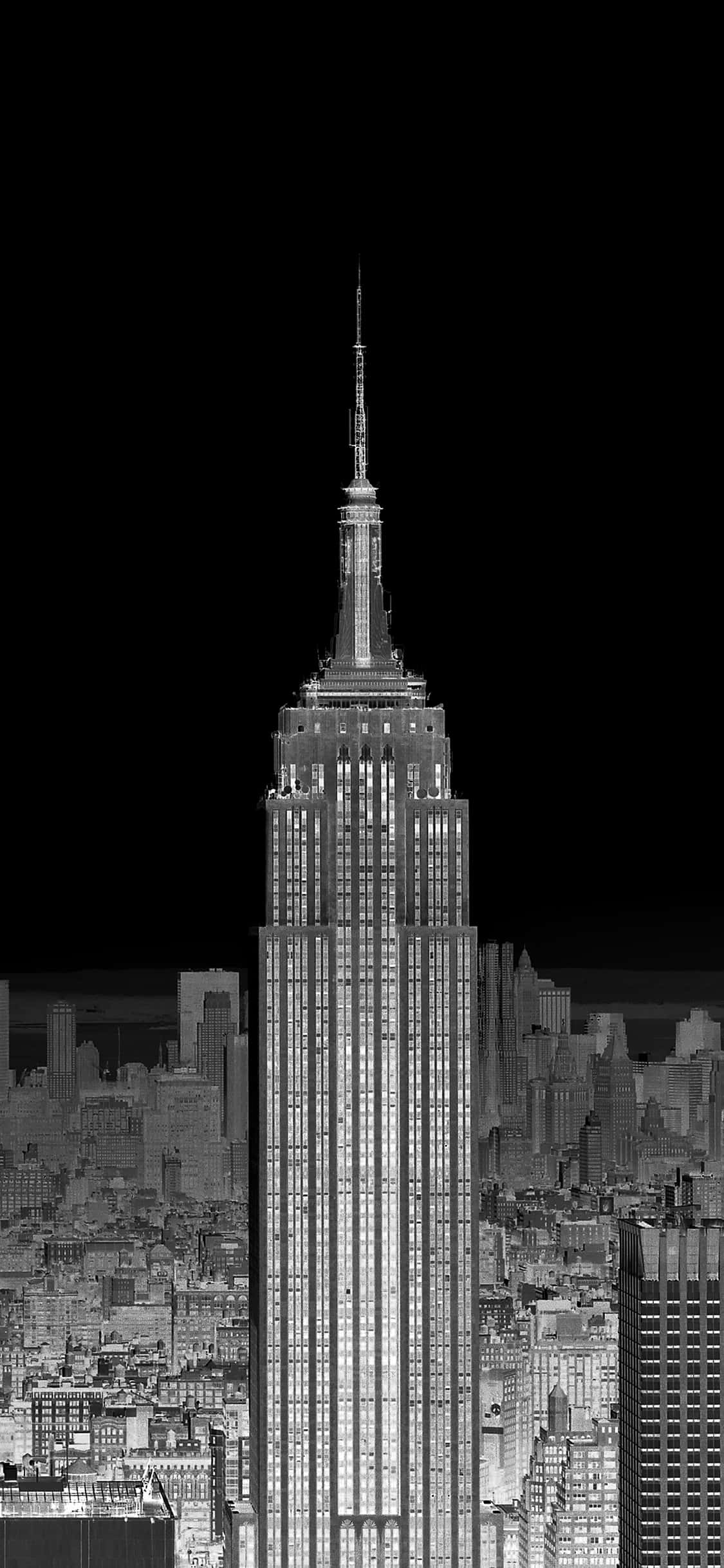 New York City Night iPhone 桌布 壁紙 — 帝國大廈在密集的紐約市天際線上高聳入雲的醒目黑白夜景。