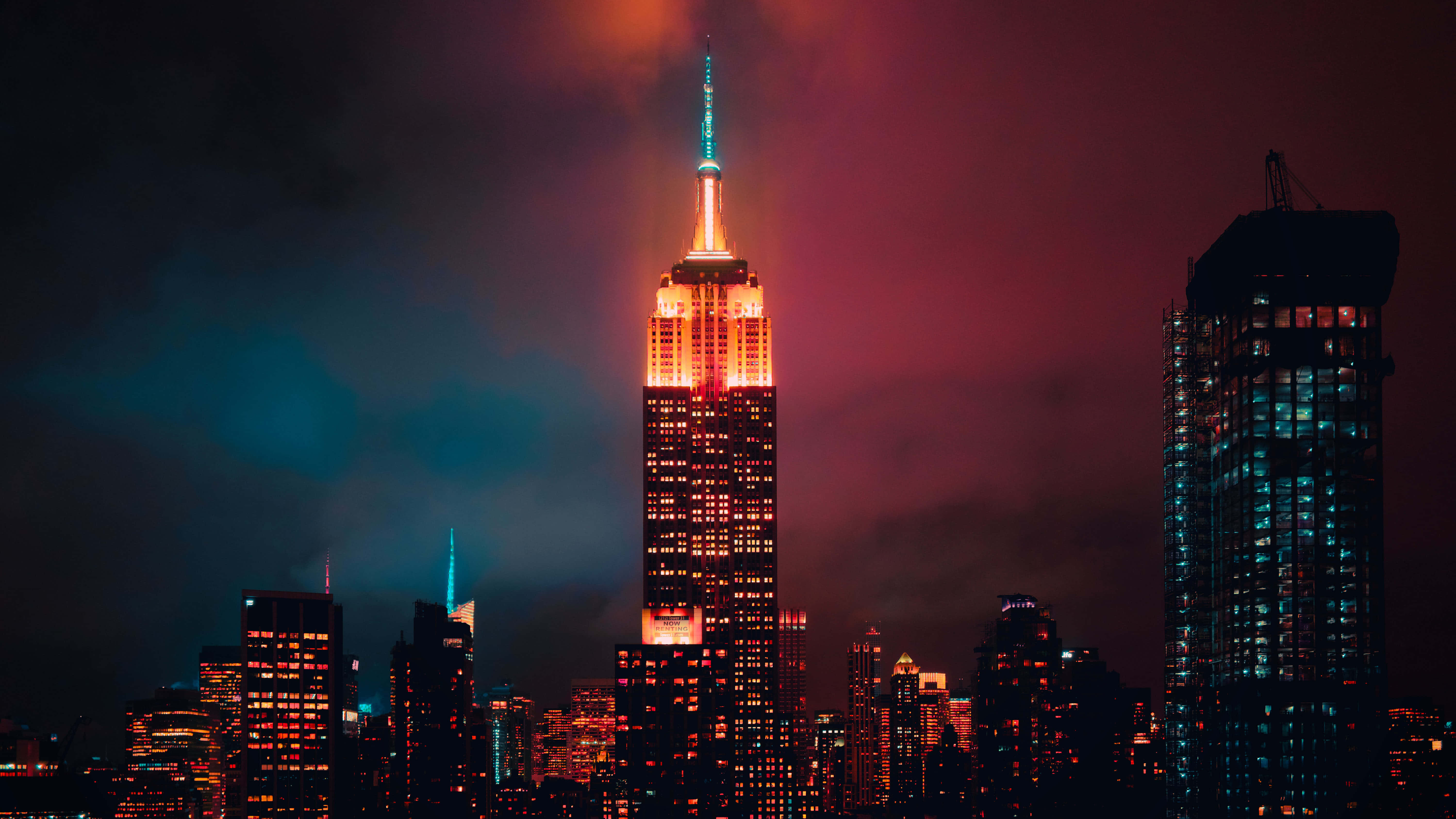Empire State Building 桌布 壁紙 — 帝國大廈在深紅和青藍色雲彩交織的戲劇性暮色天空中溫暖地發光。