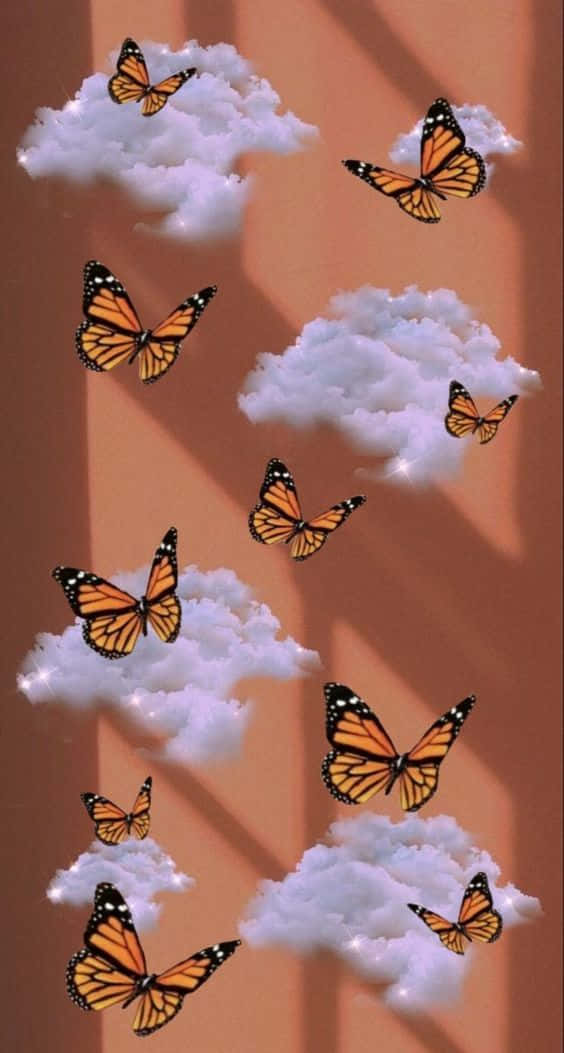 Cool Butterfly 桌布 壁紙 — 帝王蝶在柔軟的白雲中優雅地翩翩起舞，襯著溫暖的赤陶色天空。