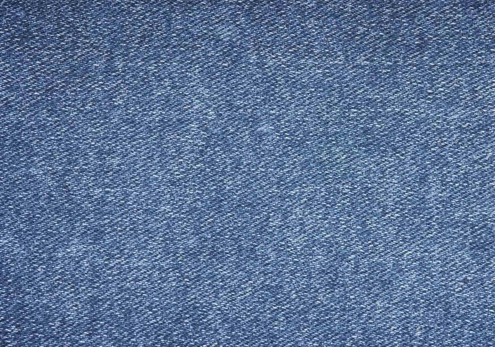 Denim Blue 桌布 壁紙 — 帶有可見編織和細微褪色的紋理藍色牛仔布料的特寫。