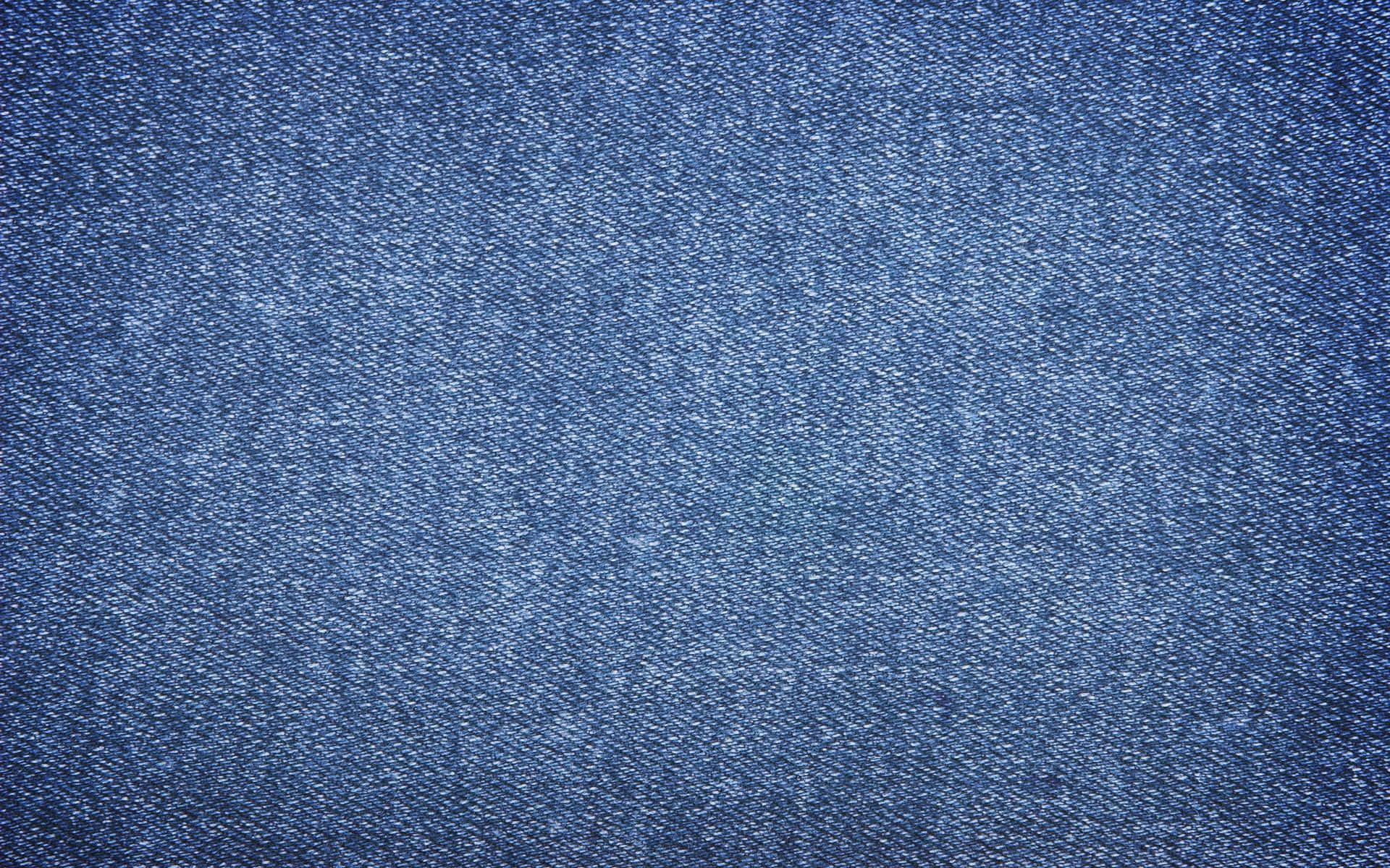 Denim 桌布 壁紙 — 帶有可見編織紋理和細微褪色變化的藍色牛仔布面料特寫。