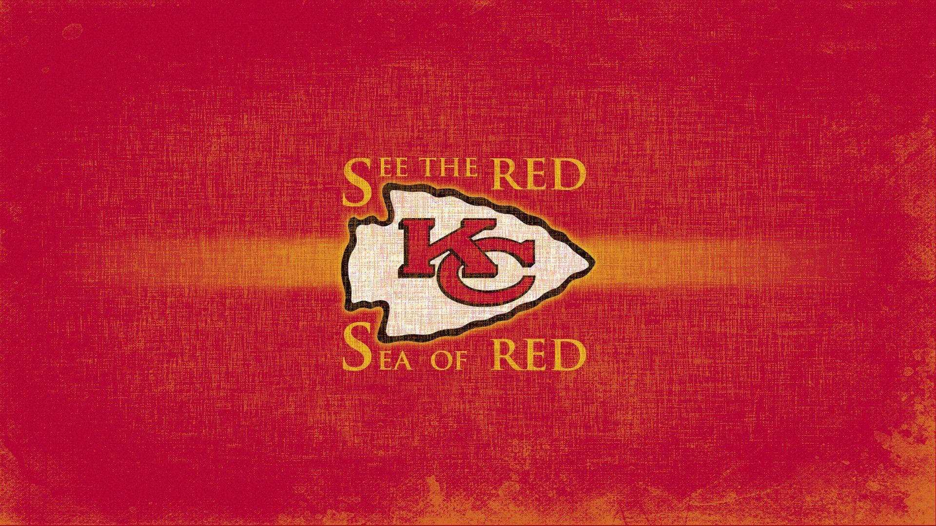 Kc Chiefs 桌布 壁紙 — 帶有堪薩斯城酋長隊標誌和「SEE THE RED SEA OF RED」文字的紋理紅色壁紙。