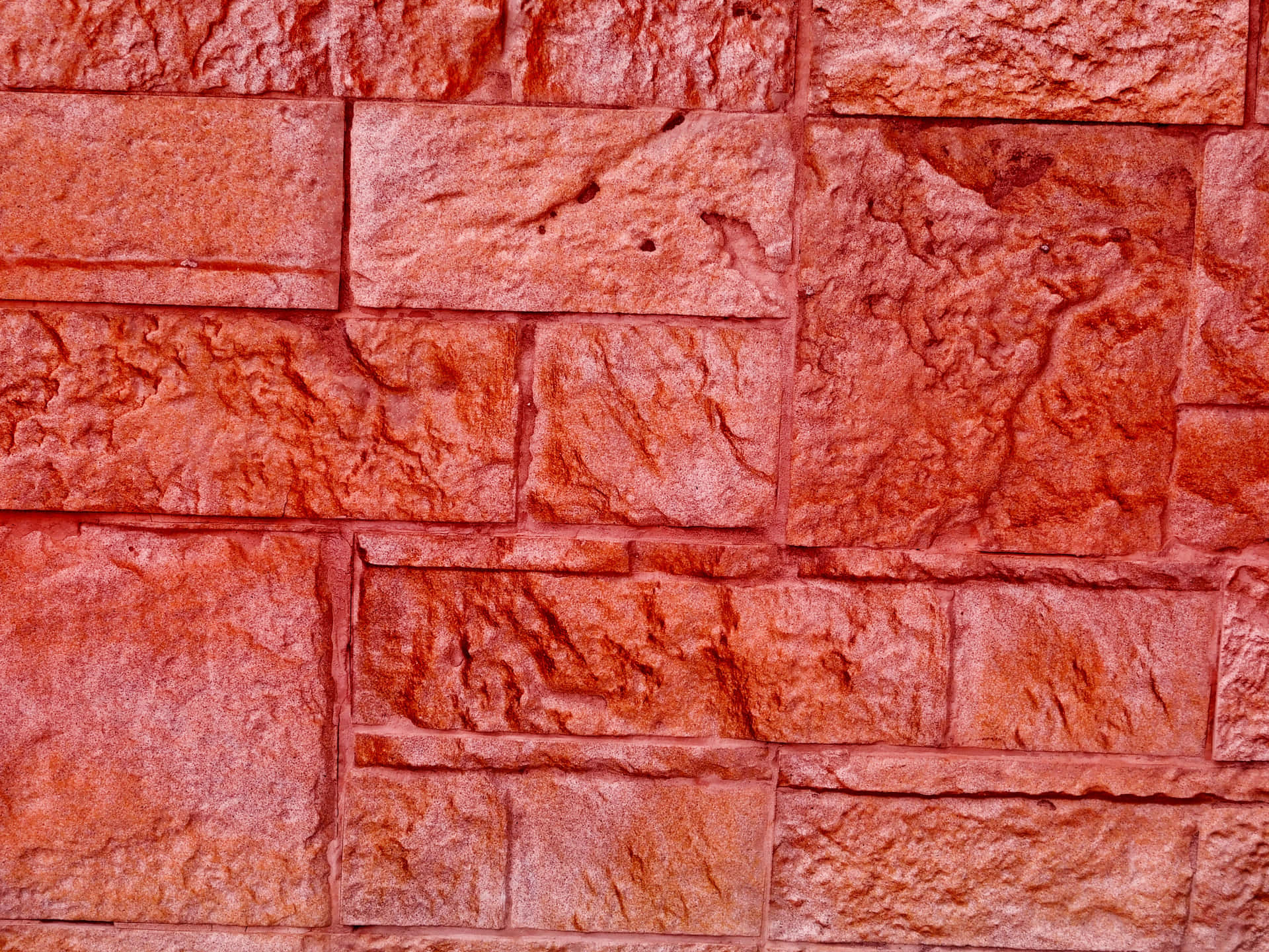 Red stone texture 壁紙 — 帶有天然紋理和細微顏色變化的紋理紅石磚，以交錯牆壁圖案排列的特寫。