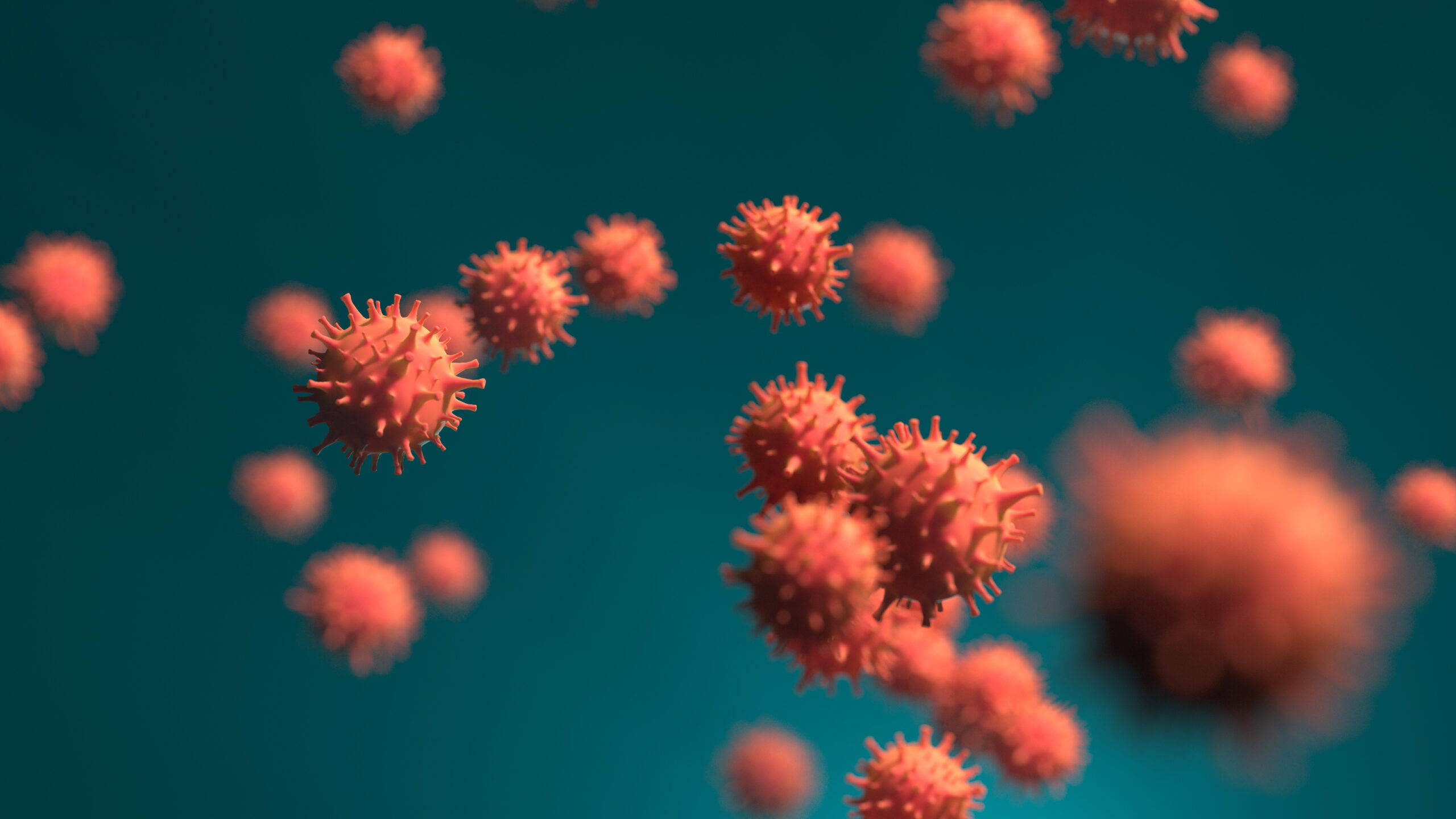 Coronavirus 桌布 壁紙 — 帶有尖刺突起的球形紅色病毒粒子在淺景深下漂浮於青綠色背景上。