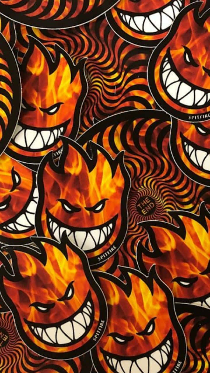 Flame 桌布 壁紙 — 帶有尖銳牙齒和旋轉橙色火焰的火熱魔鬼面孔在催眠般的迷幻背景上重複出現。
