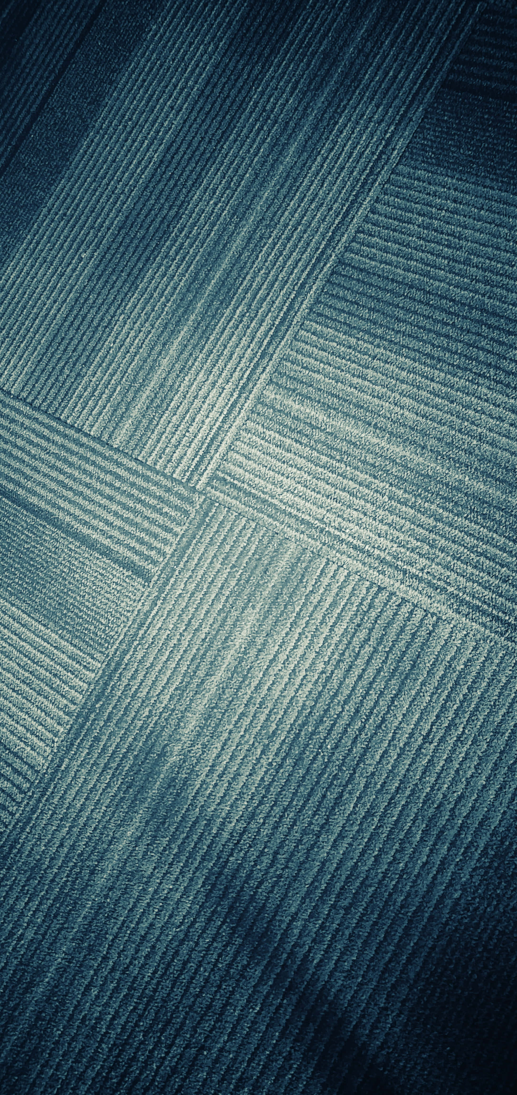 Carpet 桌布 壁紙 — 帶有幾何圖案和不同色調棱紋線條的質感藍色地毯特寫。