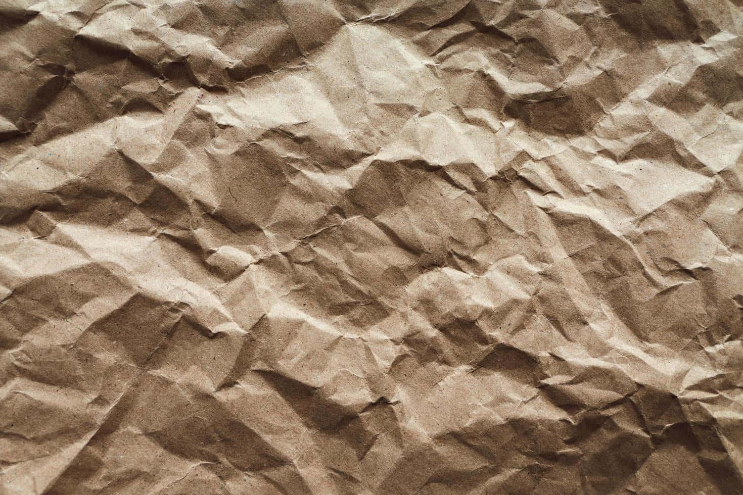 paper 桌布 壁紙 — 帶有深皺紋和柔和陰影的紋理棕色皺紙特寫。