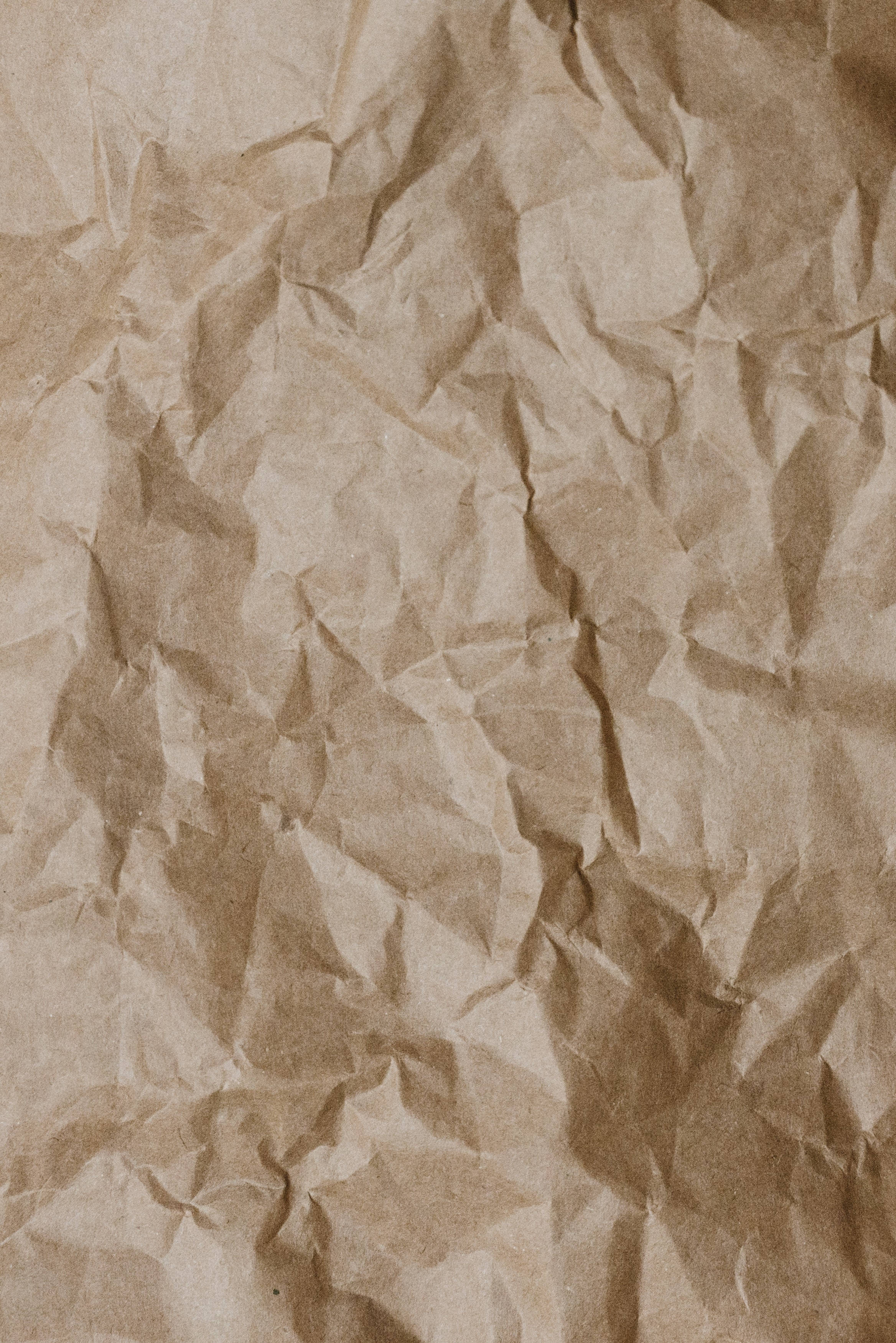 paper 桌布 壁紙 — 帶有深皺褶和柔和陰影的紋理棕色紙張特寫，營造出觸覺有機表面。