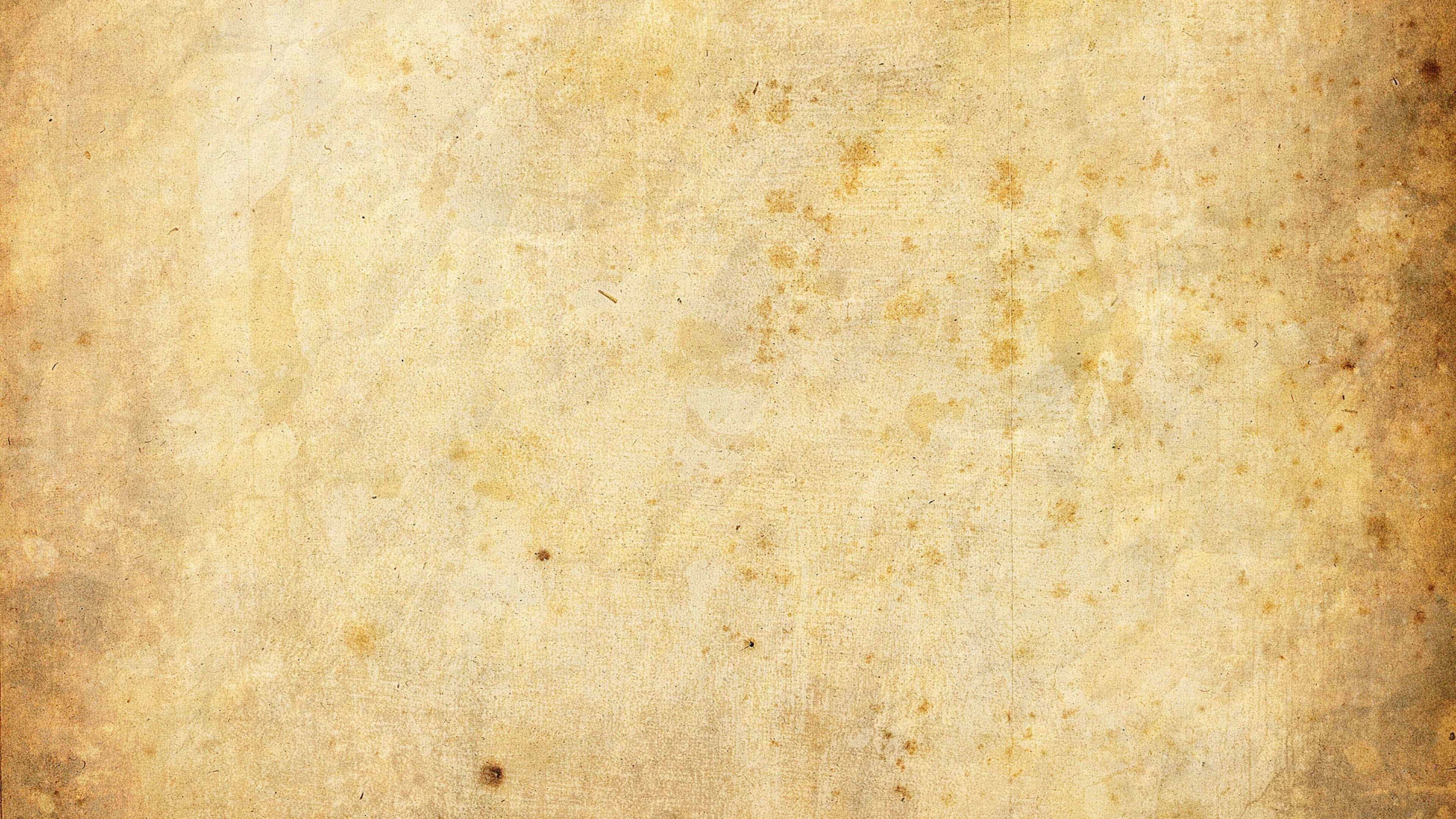 Old Paper Texture 桌布 壁紙 — 帶有溫暖米色調和細微污漬的紋理復古羊皮紙，營造出陳舊的古董感覺。