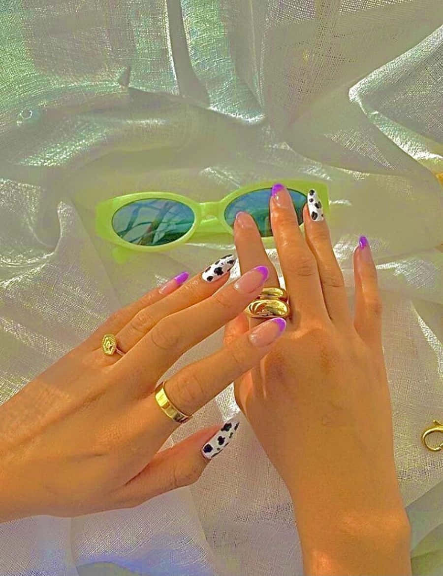 Nail 桌布 壁紙 — 帶有牛紋指甲和金色戒指的手放在薄紗布料上，旁邊是螢光綠色太陽眼鏡。