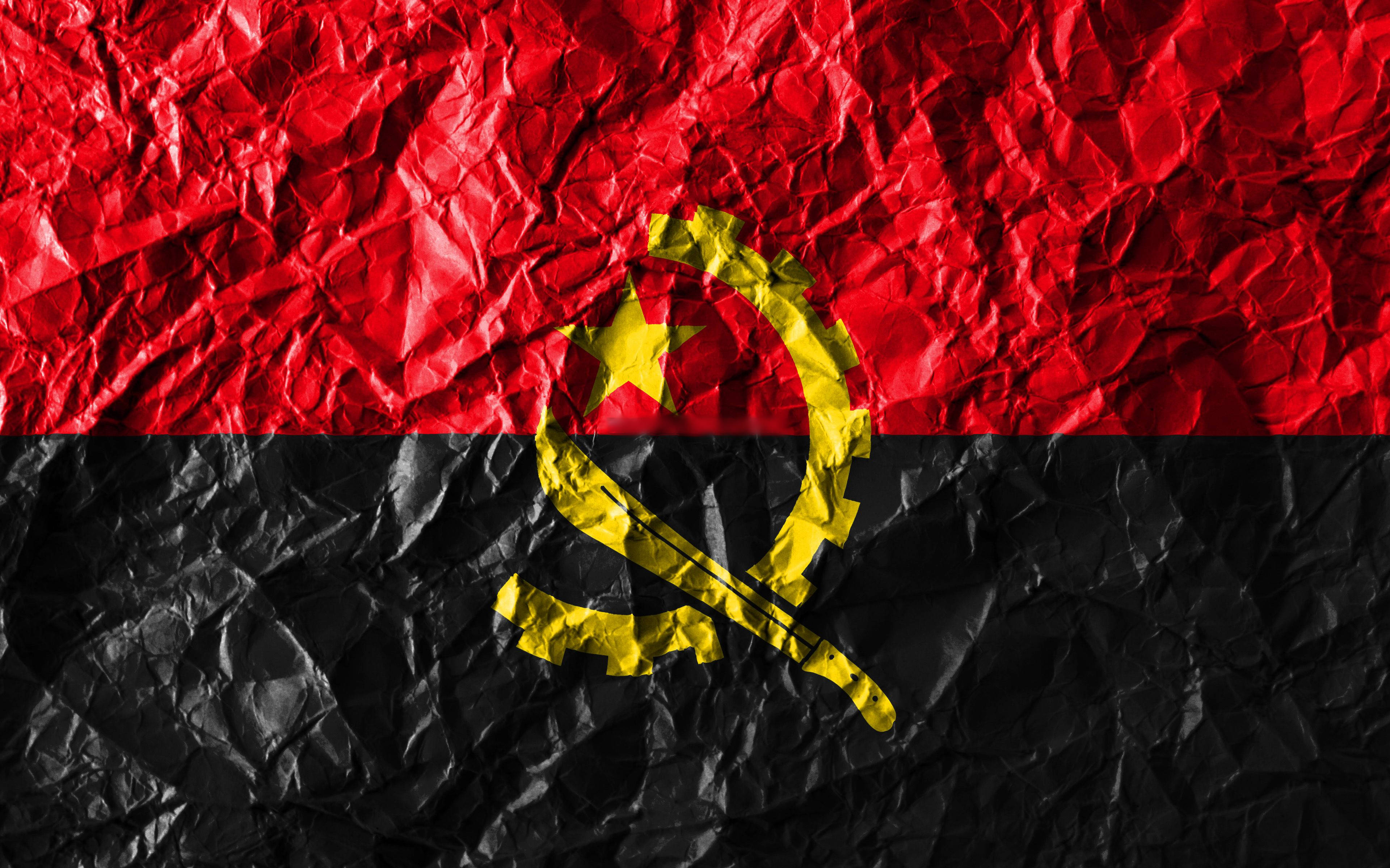 Angola 桌布 壁紙 — 帶有紅色和黑色條紋及黃色徽章的皺巴巴安哥拉國旗，顯示質感和摺痕。