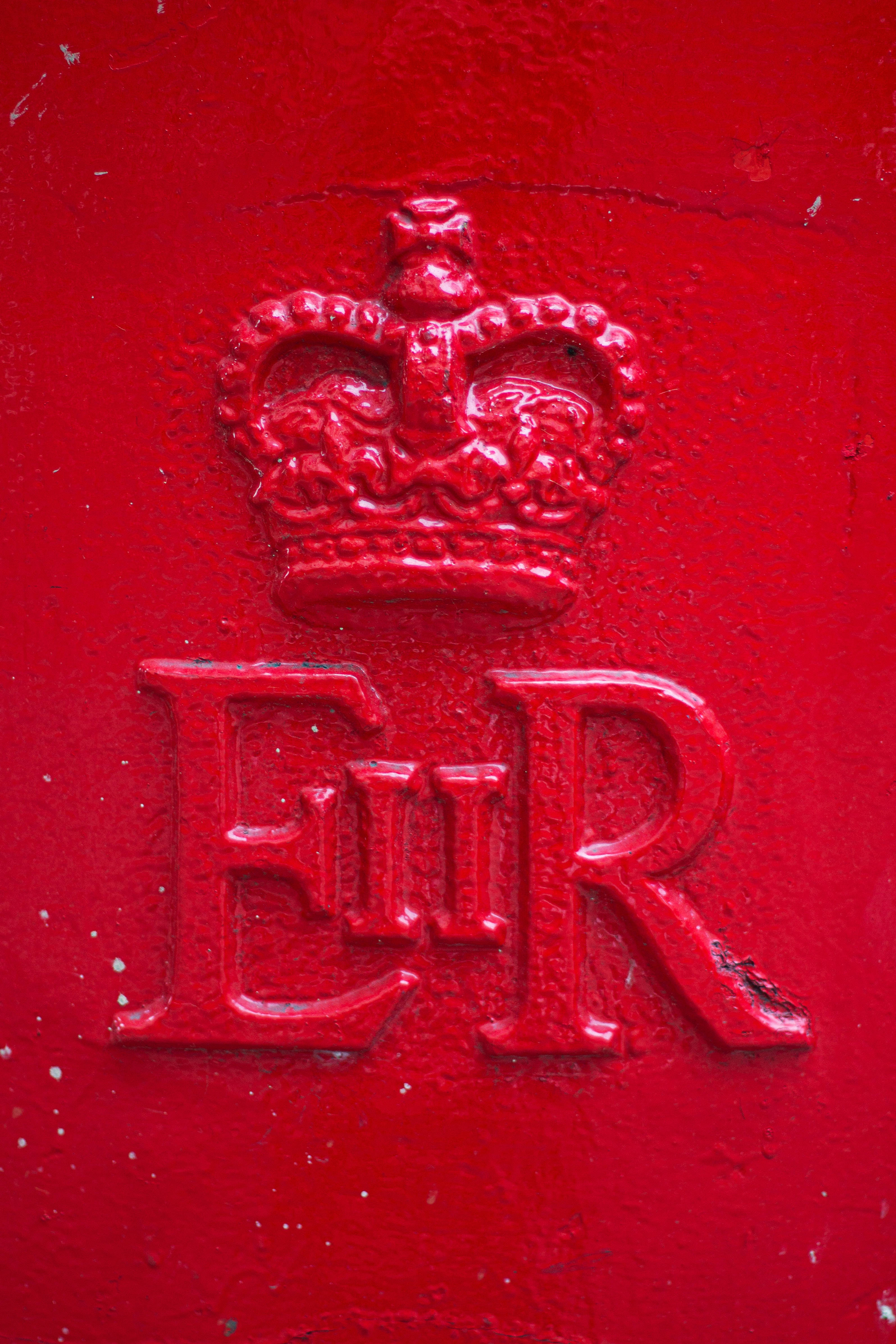 England 桌布 壁紙 — 帶有紋理的紅色英國郵筒特寫，具有凸起的皇冠和「ER」皇家字母組合。