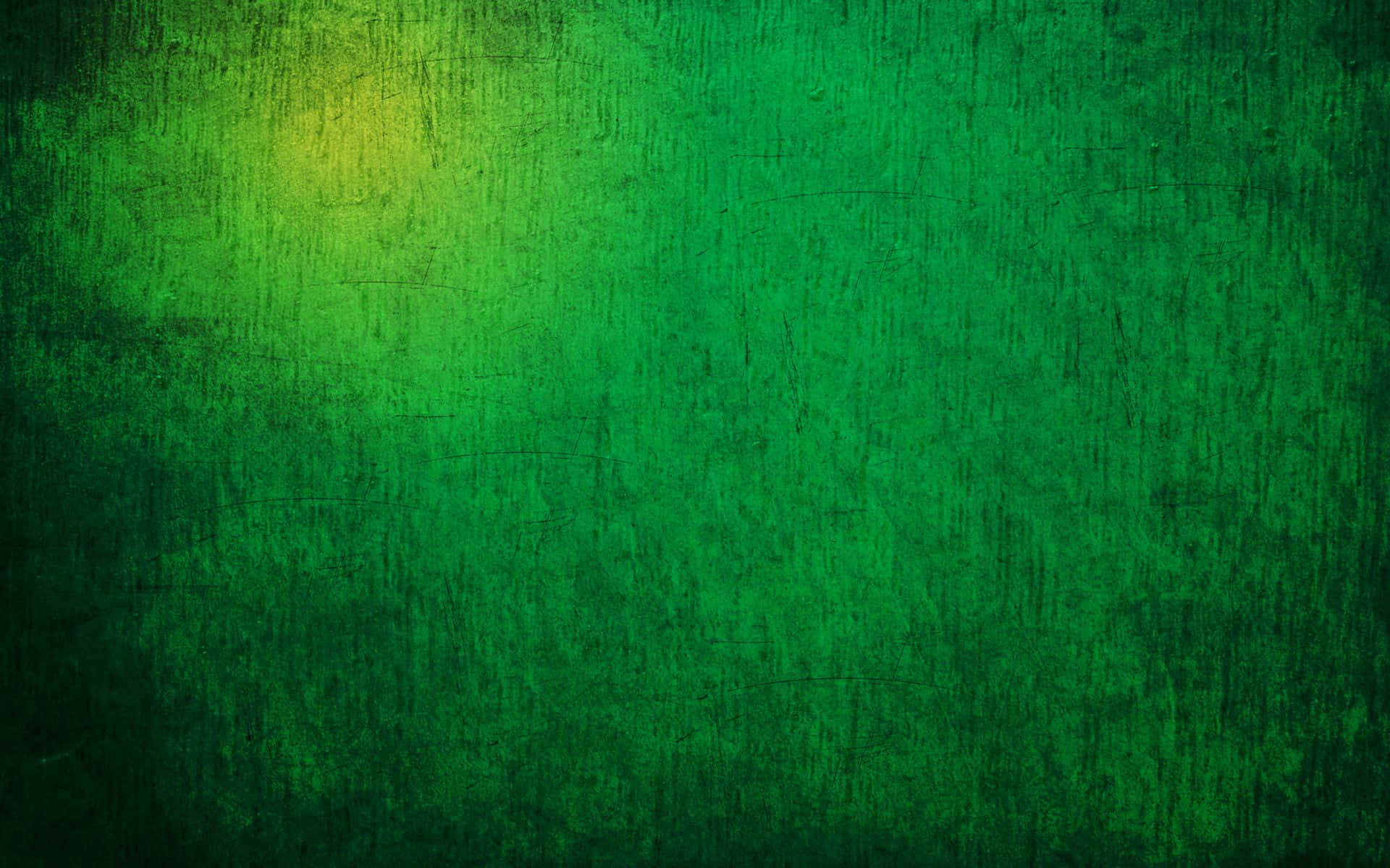 Dark Green Grunge 桌布 壁紙 — 帶有紋理的綠色漸變背景，左上角有微妙的黃色光芒。