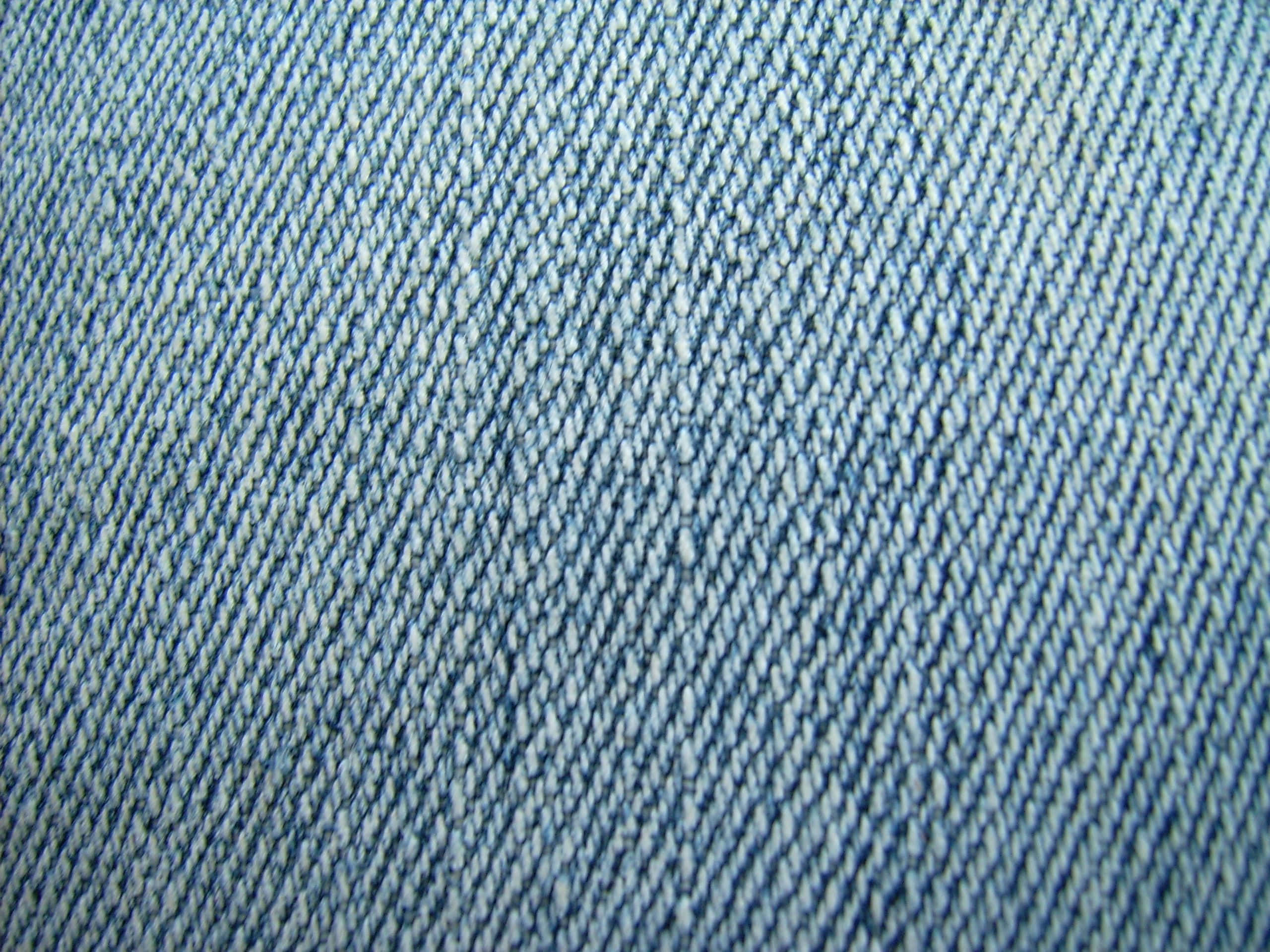 Denim 桌布 壁紙 — 帶有紋理的藍色牛仔布面料特寫，顯示斜紋編織和輕微褪色。