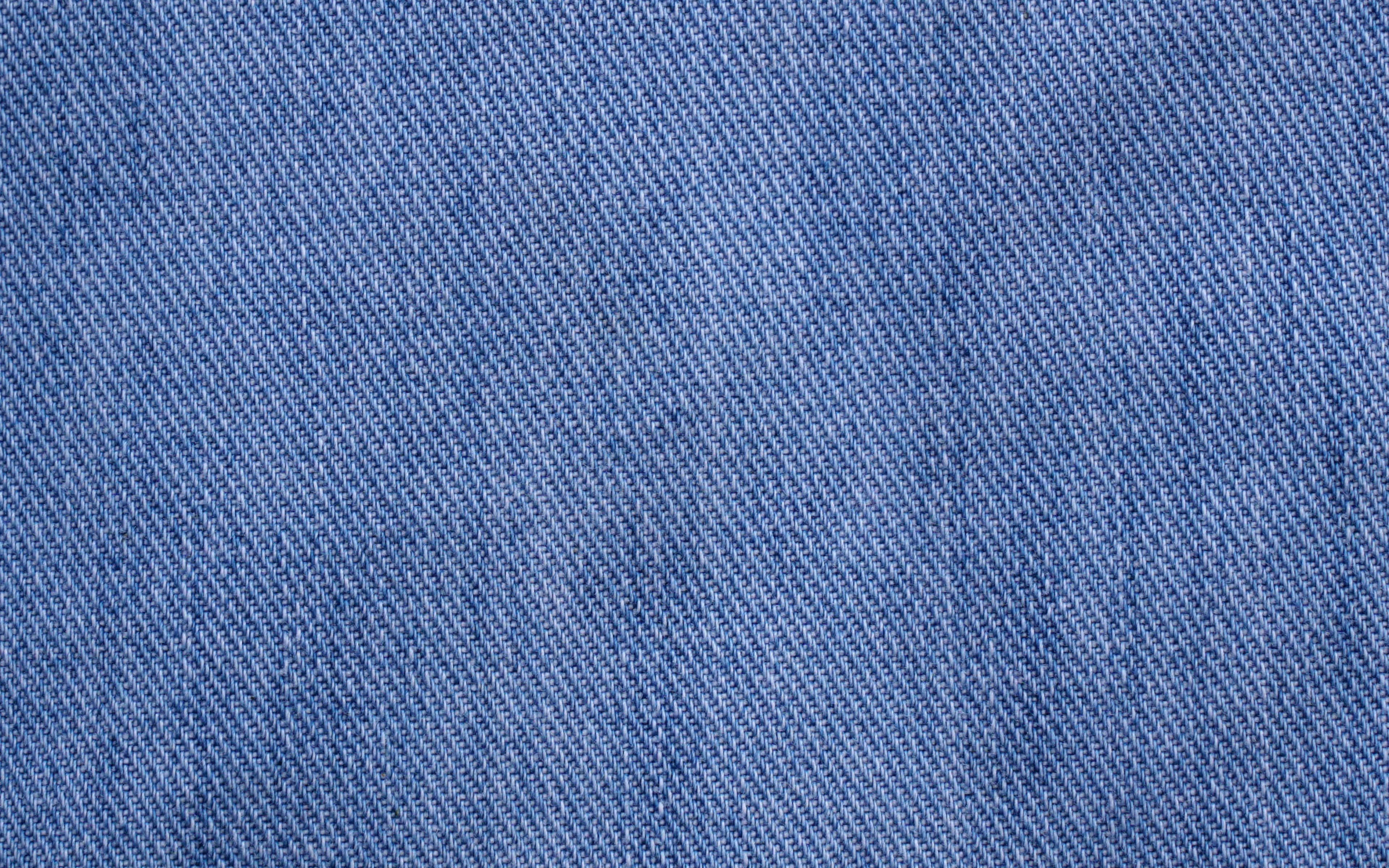 Denim 桌布 壁紙 — 帶有紋理的藍色牛仔布面料特寫，顯示斜紋編織和微妙的褪色。