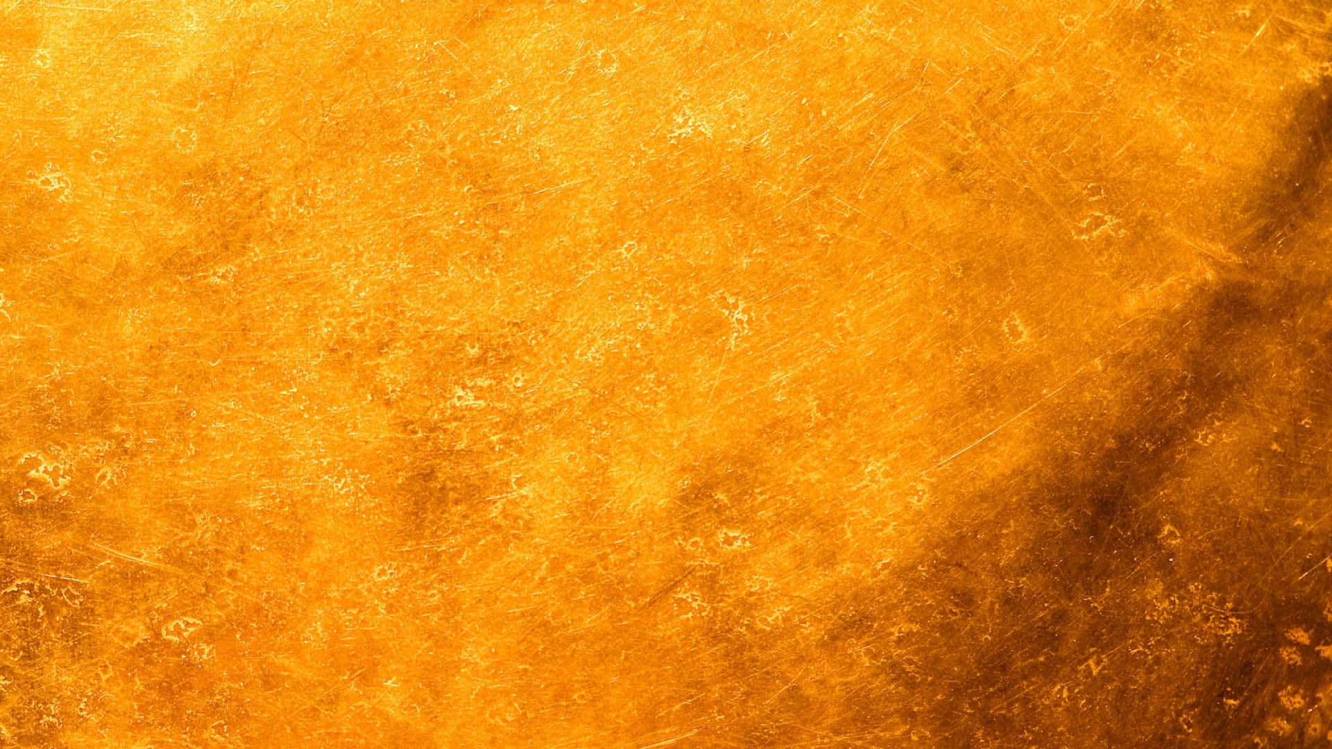 Yellow Grunge 桌布 壁紙 — 帶有細微刮痕和斑駁圖案的金色紋理表面，在整個畫面中溫暖地發光。