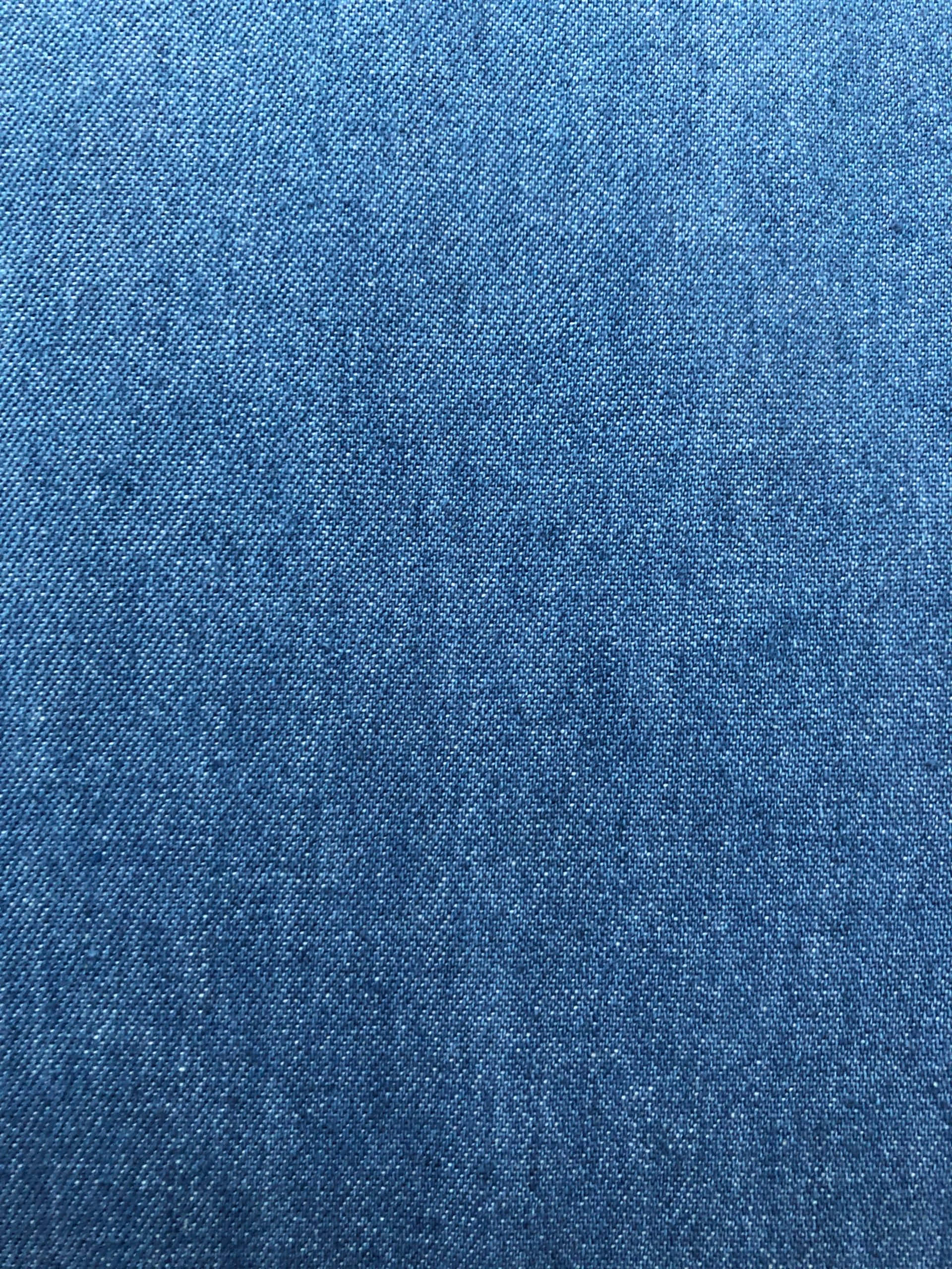 Denim Blue 桌布 壁紙 — 帶有細微漸變和可見編織圖案的紋理藍色牛仔布料的特寫。
