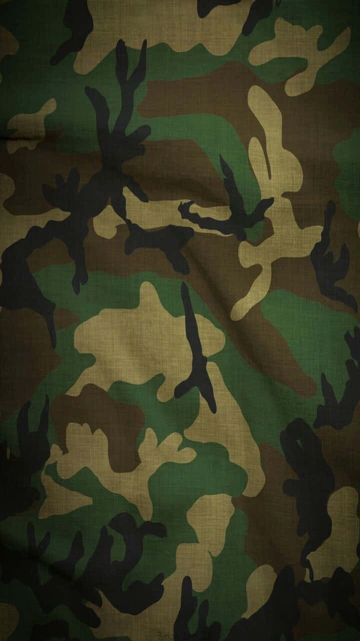 軍事動圖 桌布 壁紙 — 帶有綠色、棕色和黑色斑點、顯示自然褶皺的紋理軍用迷彩布料特寫。
