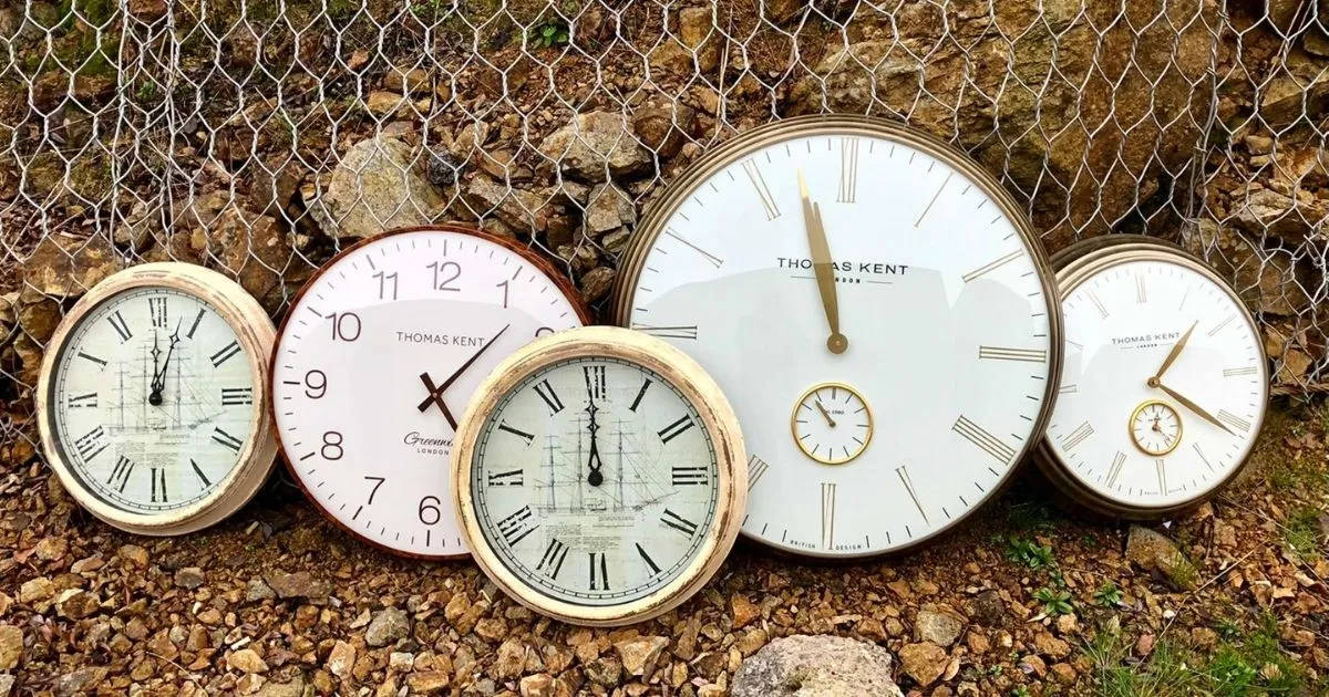 Clock 桌布 壁紙 — 帶有羅馬數字和船隻地圖的復古時鐘，放在鐵絲網圍欄旁的礫石上。