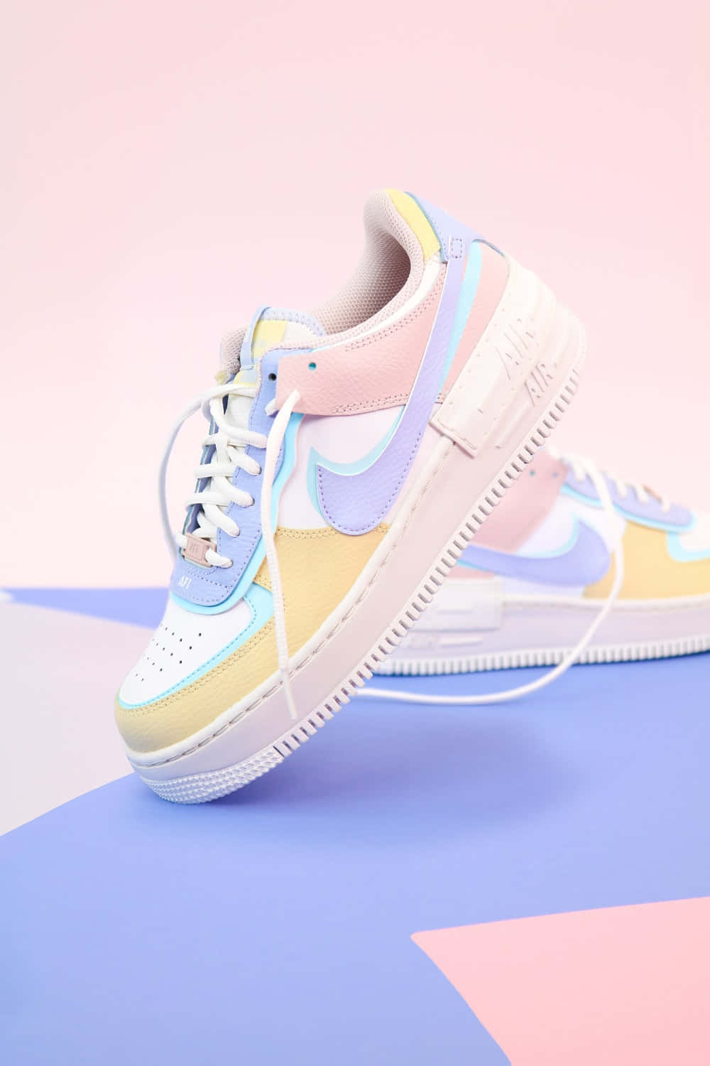Cute Shoes 桌布 壁紙 — 帶有薰衣草、黃色和粉紅色點綴的柔和色調Nike運動鞋，放置在幾何粉藍色表面上。