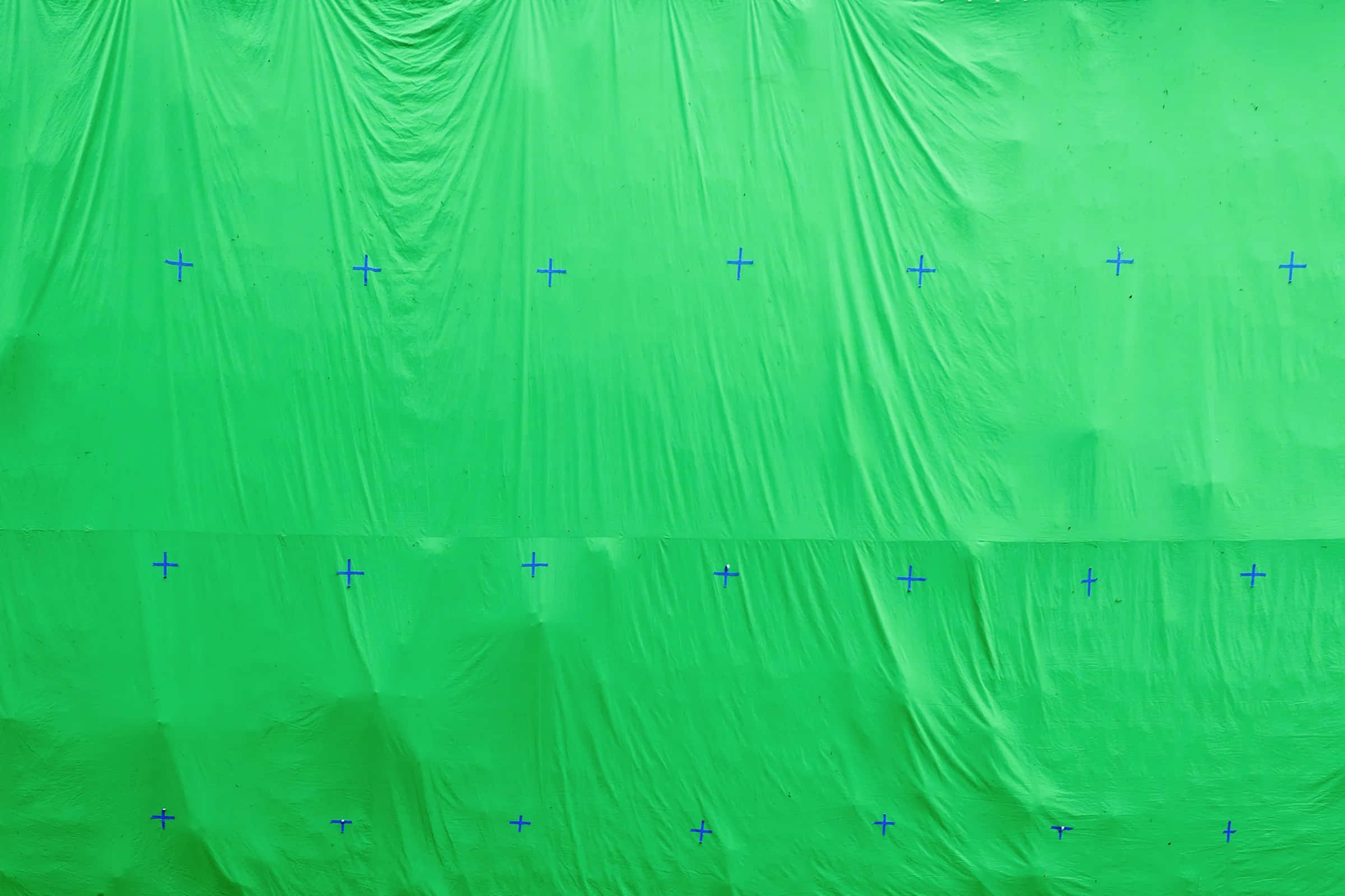 Backdrop 桌布 壁紙 — 帶有藍色十字準線標記排列成行的皺褶綠色布料背景。