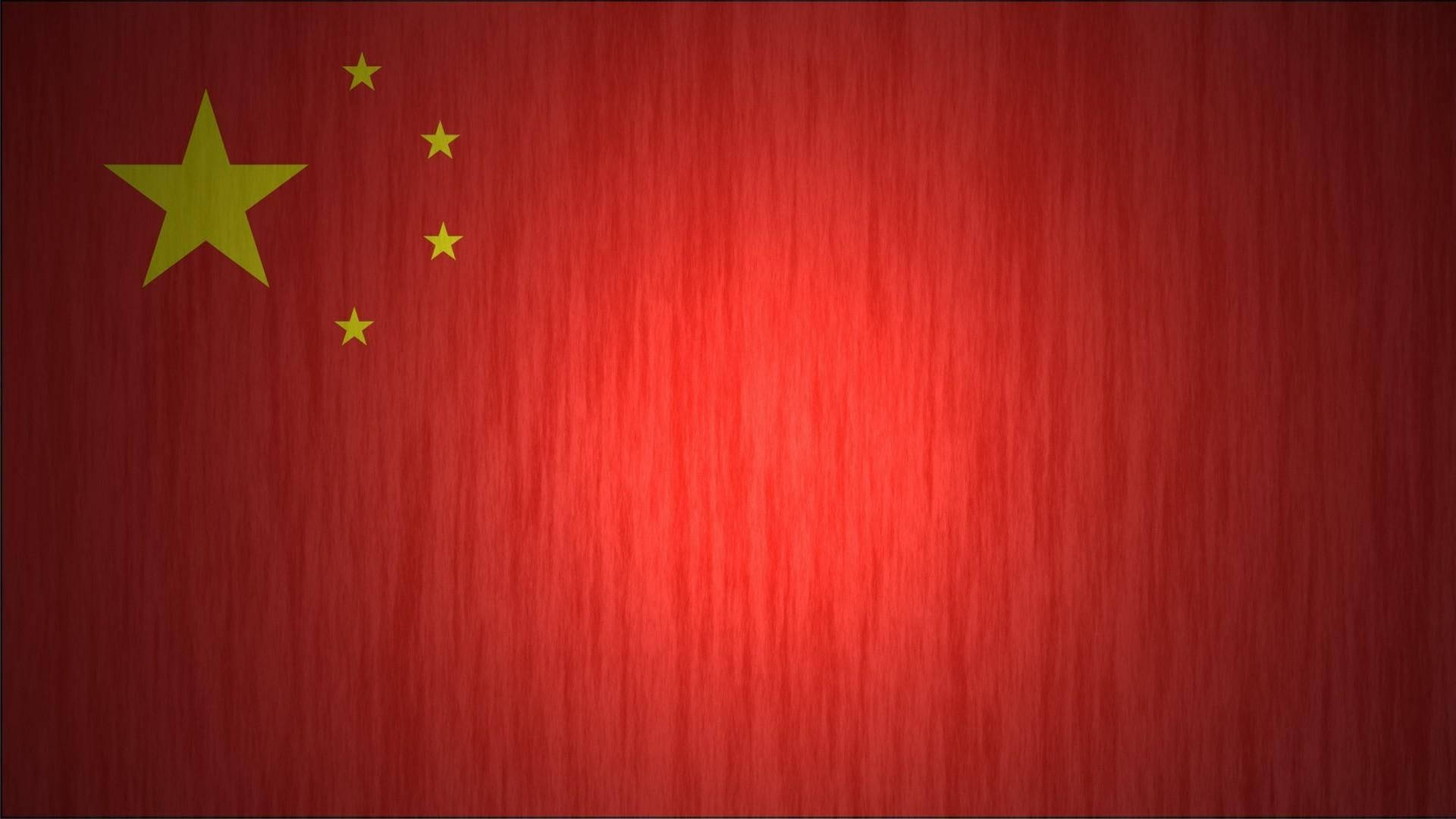 帶有金色星星的中國國旗，置於有紋理的紅色布料上。