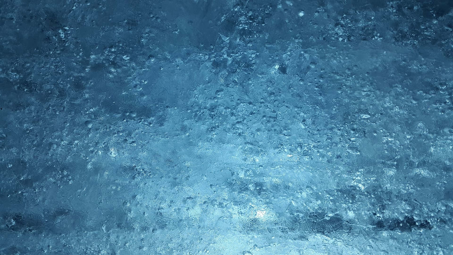 Frost 桌布 壁紙 — 帶有閃爍晶體圖案和微妙光線反射的紋理藍色冰塊特寫。