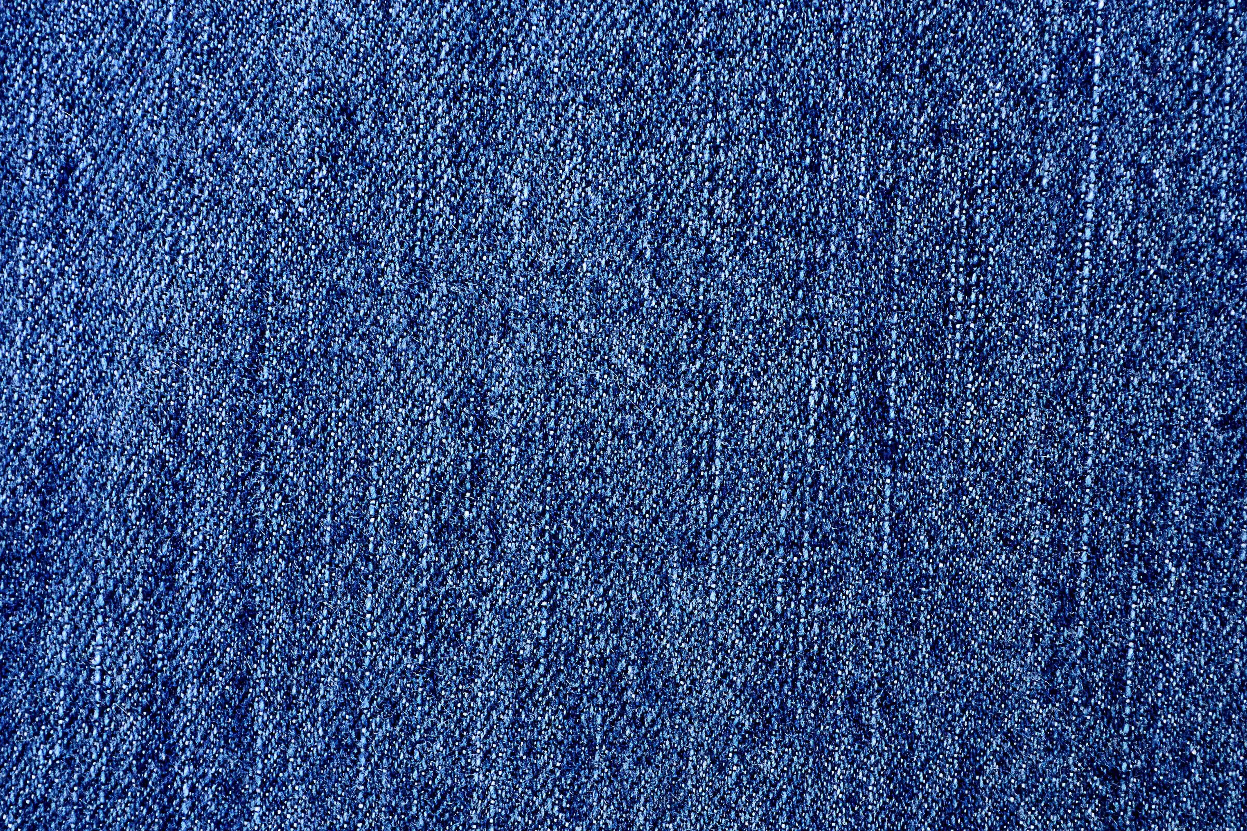 Denim 桌布 壁紙 — 帶紋理的藍色牛仔布特寫，顯示細緻的編織和微妙的褪色圖案。