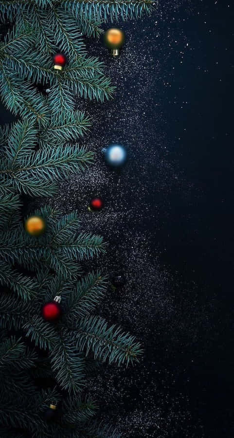 Aesthetic Christmas Tree 桌布 壁紙 — 常綠松樹枝條上裝飾著紅色和金色的飾物，在閃爍的深色夜空下飄動。