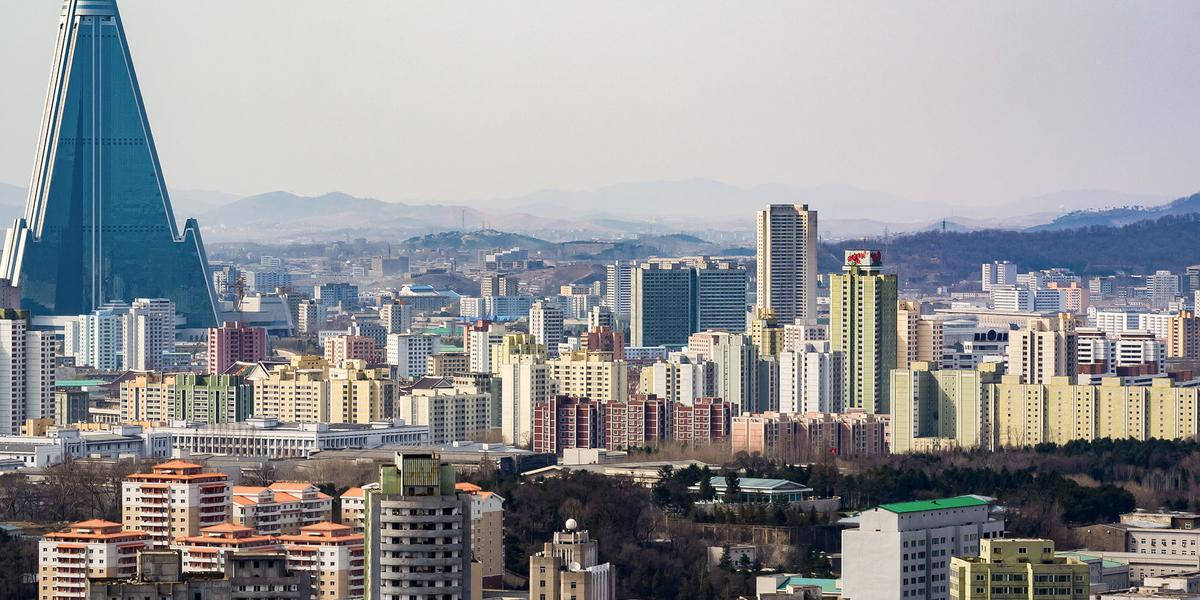 韓國 桌布 壁紙 — 平壤天際線的全景，以標誌性的柳京飯店和密集的城市建築為主導，天空朦朧。