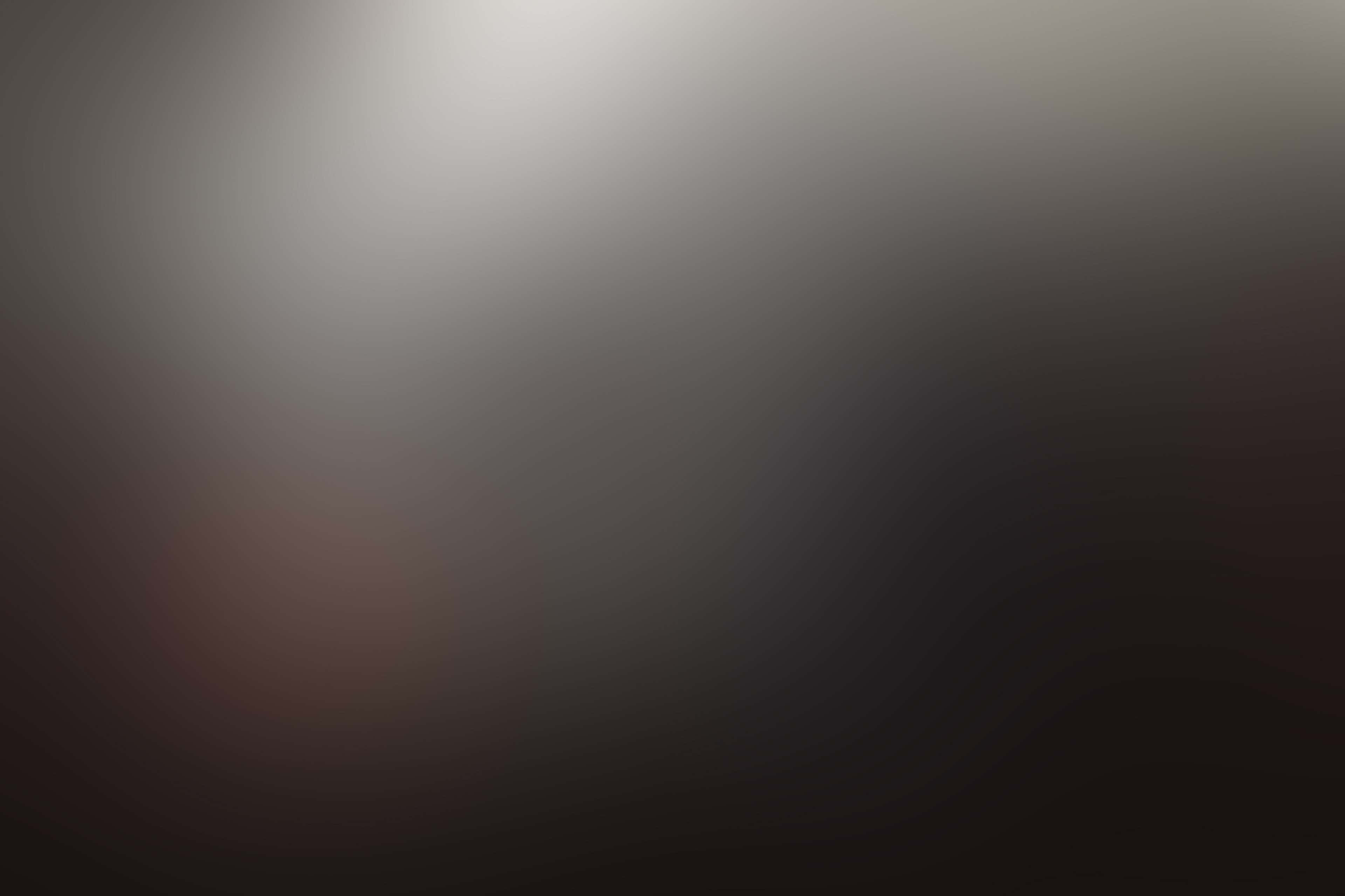 Black Gradient 桌布 壁紙 — 平滑漸變背景，從亮白色漸變到深黑色，左下角帶有微妙的淡紅色光芒。