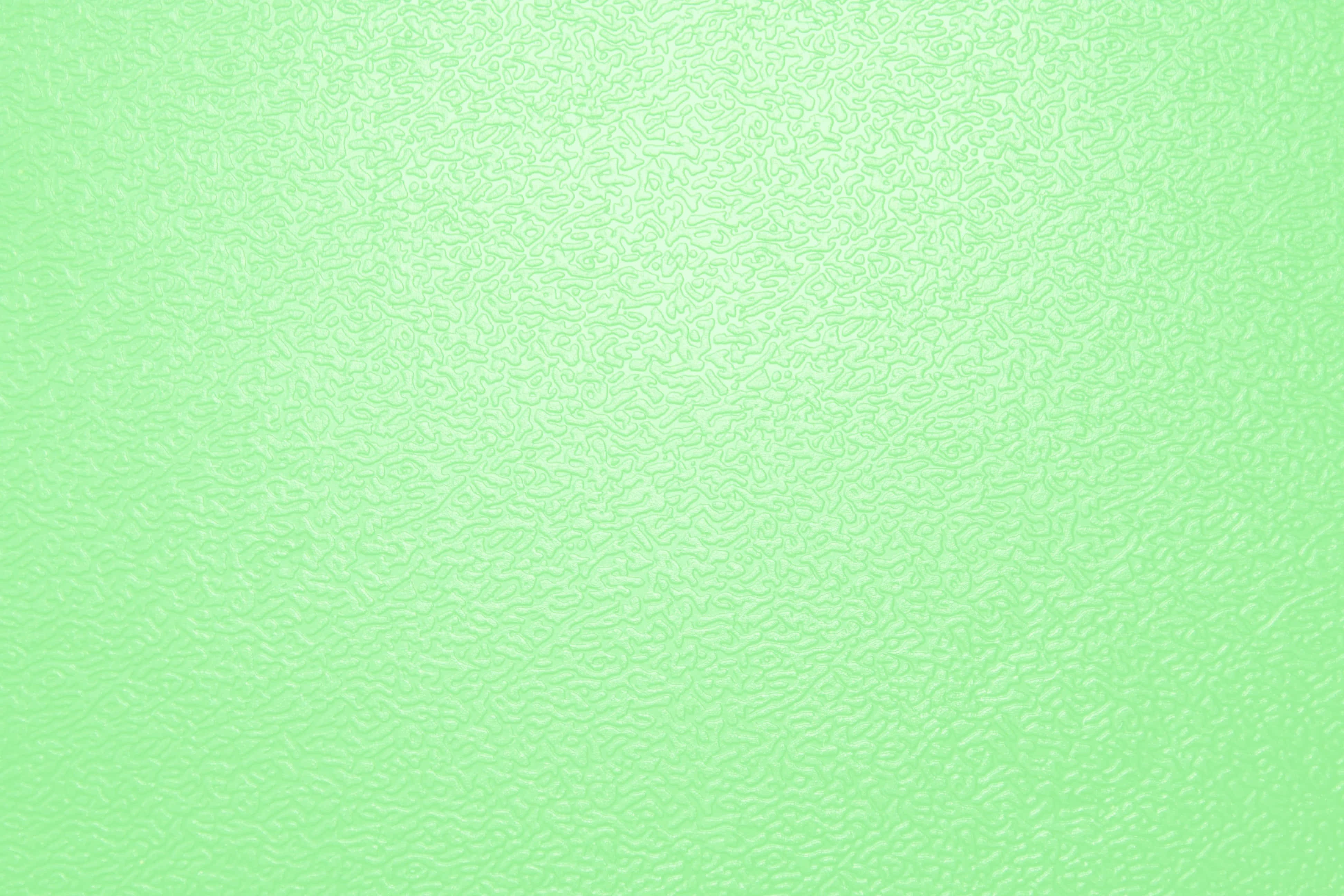 Light Green 桌布 壁紙 — 平滑的薄荷綠色表面，帶有微妙的漩渦紋理，在柔和均勻的光線下。