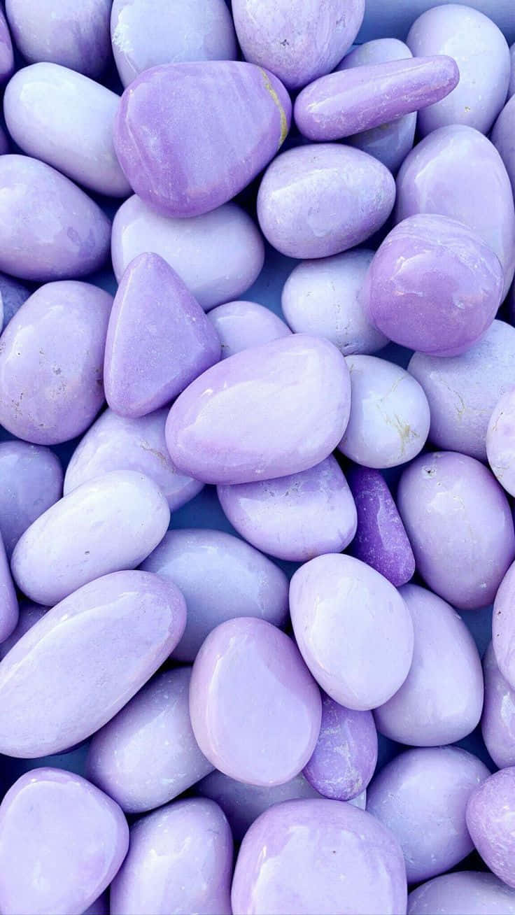 Stone 桌布 壁紙 — 平滑薰衣草色和白色河石的近距離特寫，表面光滑，帶有柔和自然曲線。