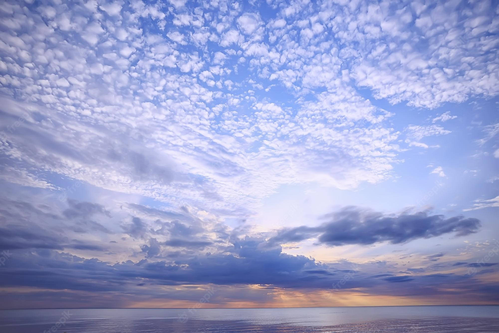 Clouds Aesthetics 桌布 壁紙 — 平靜海洋上柔和紫色與金色雲彩倒映水中的寧靜日落。