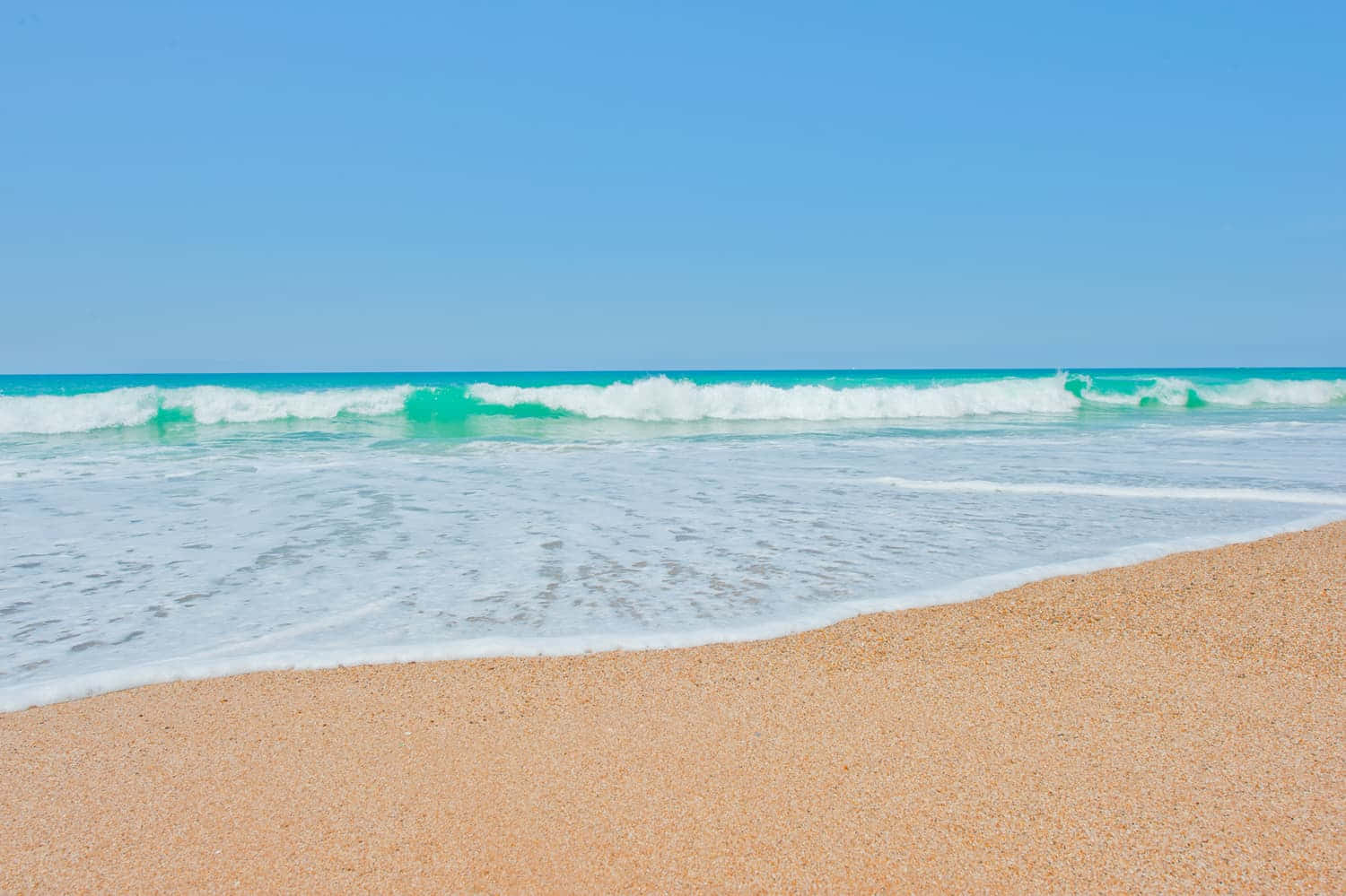 French Beach 桌布 壁紙 — 平靜的碧綠海浪輕輕拍打著金色沙灘，天空湛藍清澈。