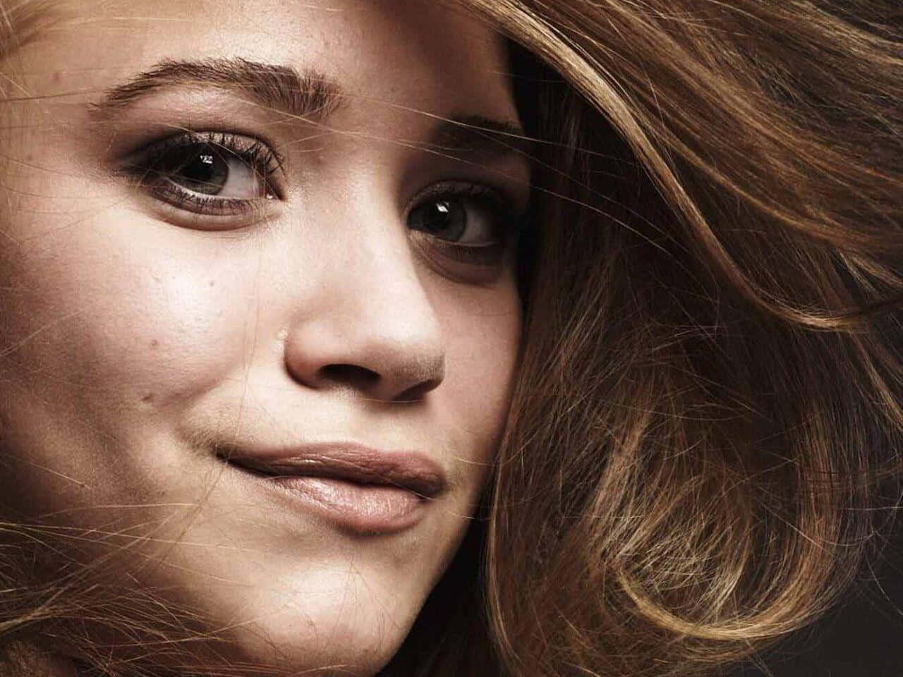 Mary Kate Olsen 桌布 壁紙 — 年輕女性棕色頭髮柔和微笑直視觀眾的特寫肖像。