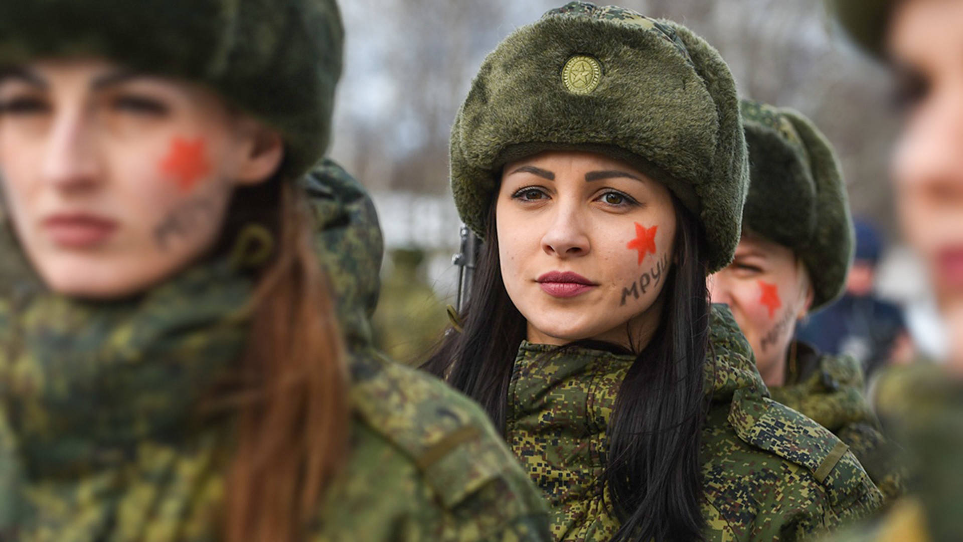 Woman 桌布 壁紙 — 年輕女性身穿軍裝和毛帽，臉上畫著紅星，在寒冷的戶外莊嚴地站立。